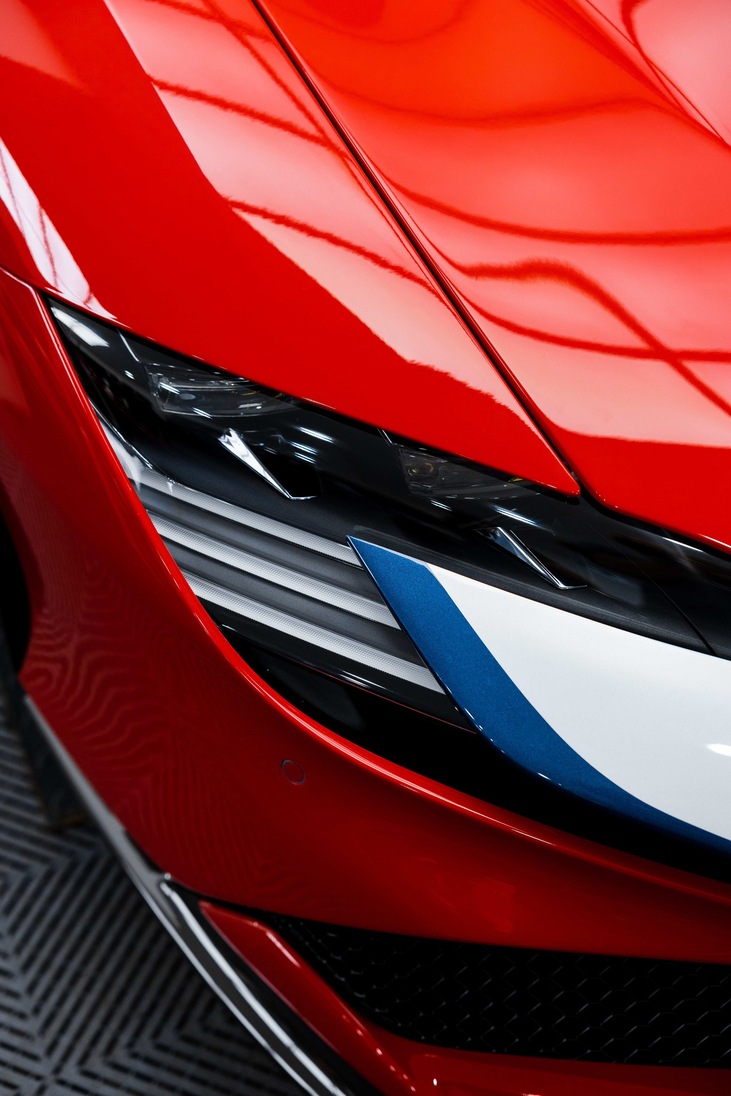 Red Ferrari SF90 Spyder bonnet and headlight with blue and white stripe and XPEL Paint Protection Film in Mona Vale