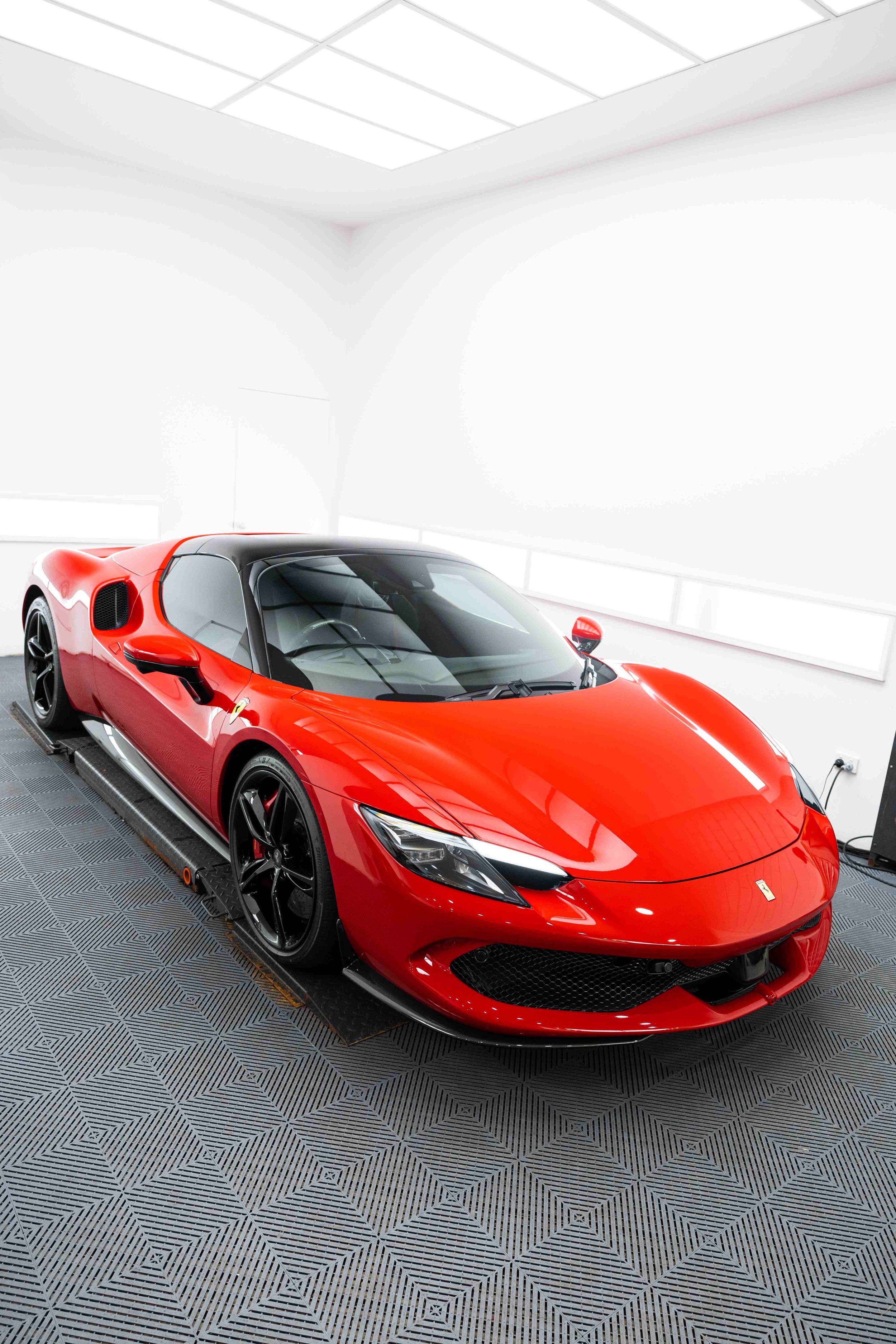 Red Ferrari 296 GTS front three quarter in studio with XPEL Paint Protection Film in Mona Vale