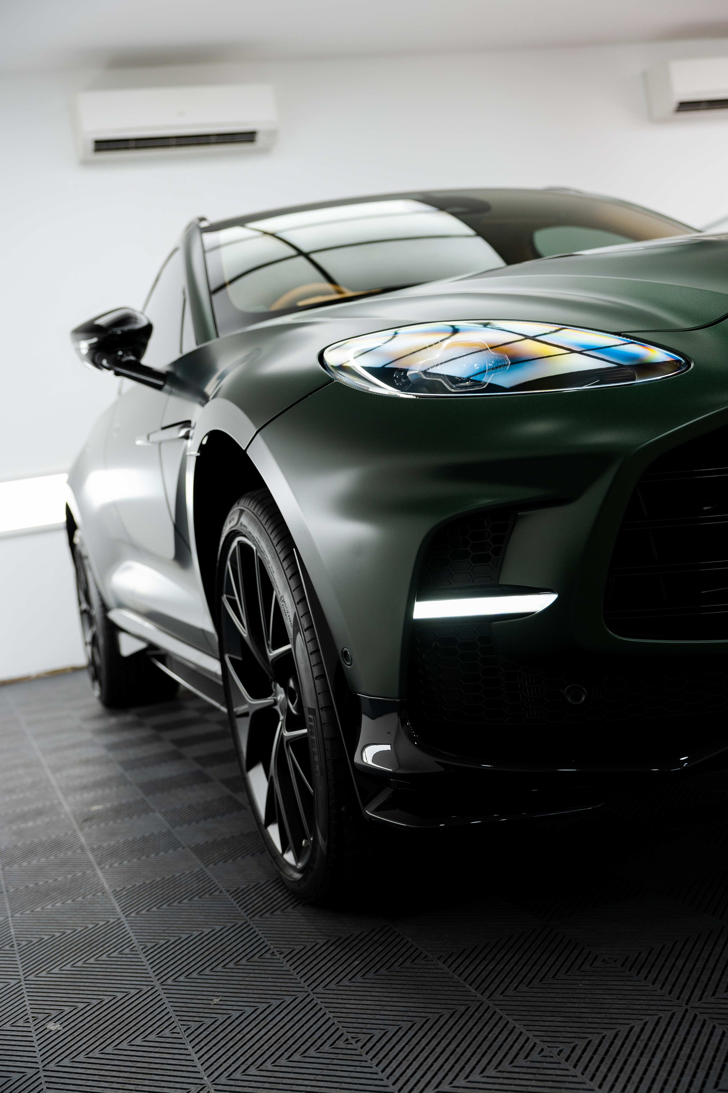 Matte green Aston Martin DBX headlight and grille detail with XPEL Stealth Paint Protection Film in Mona Vale