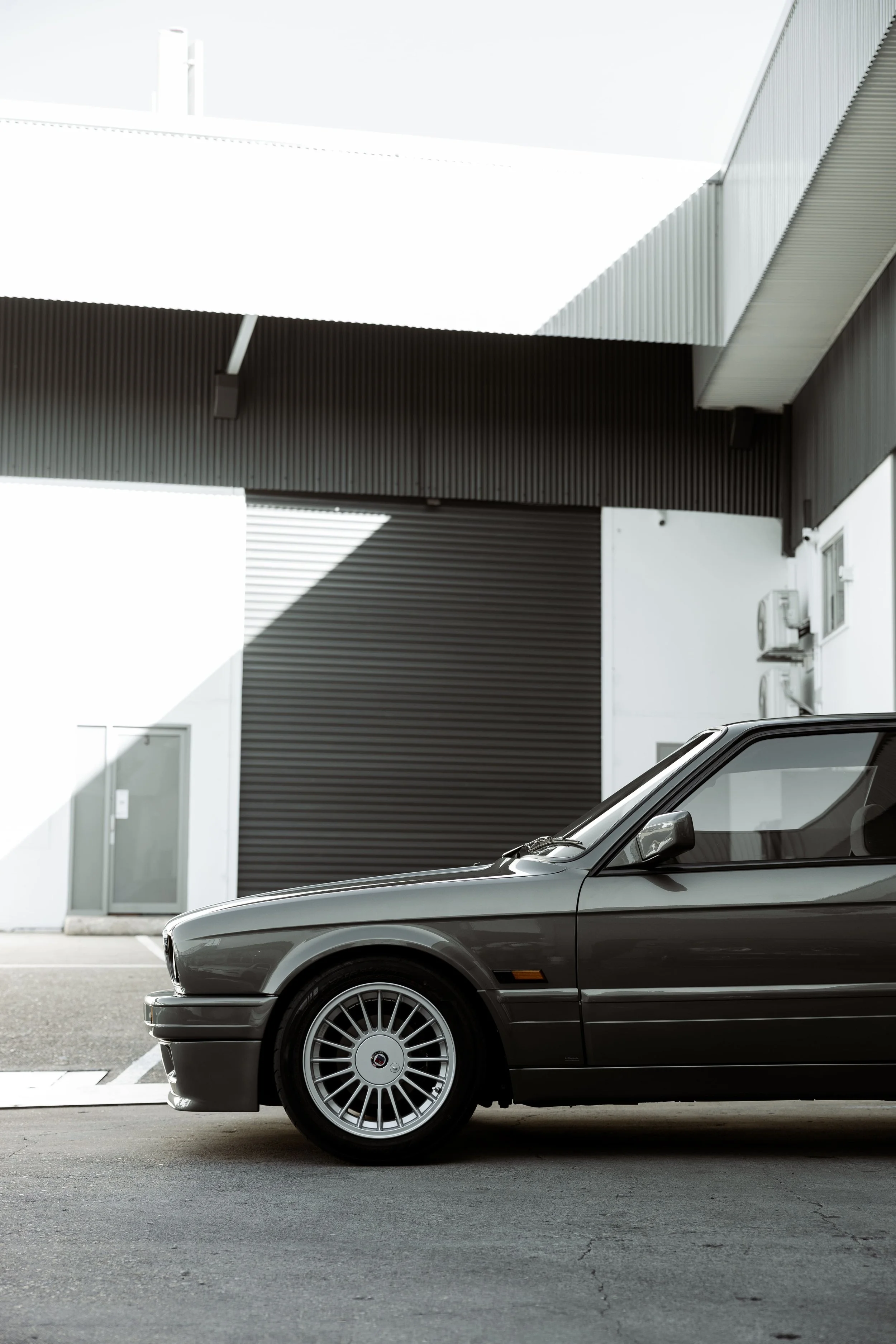 BMW E30 side profile with classic boxy design and period-correct wheels, showcasing timeless styling preserved by Australian Detailing Services Sydney