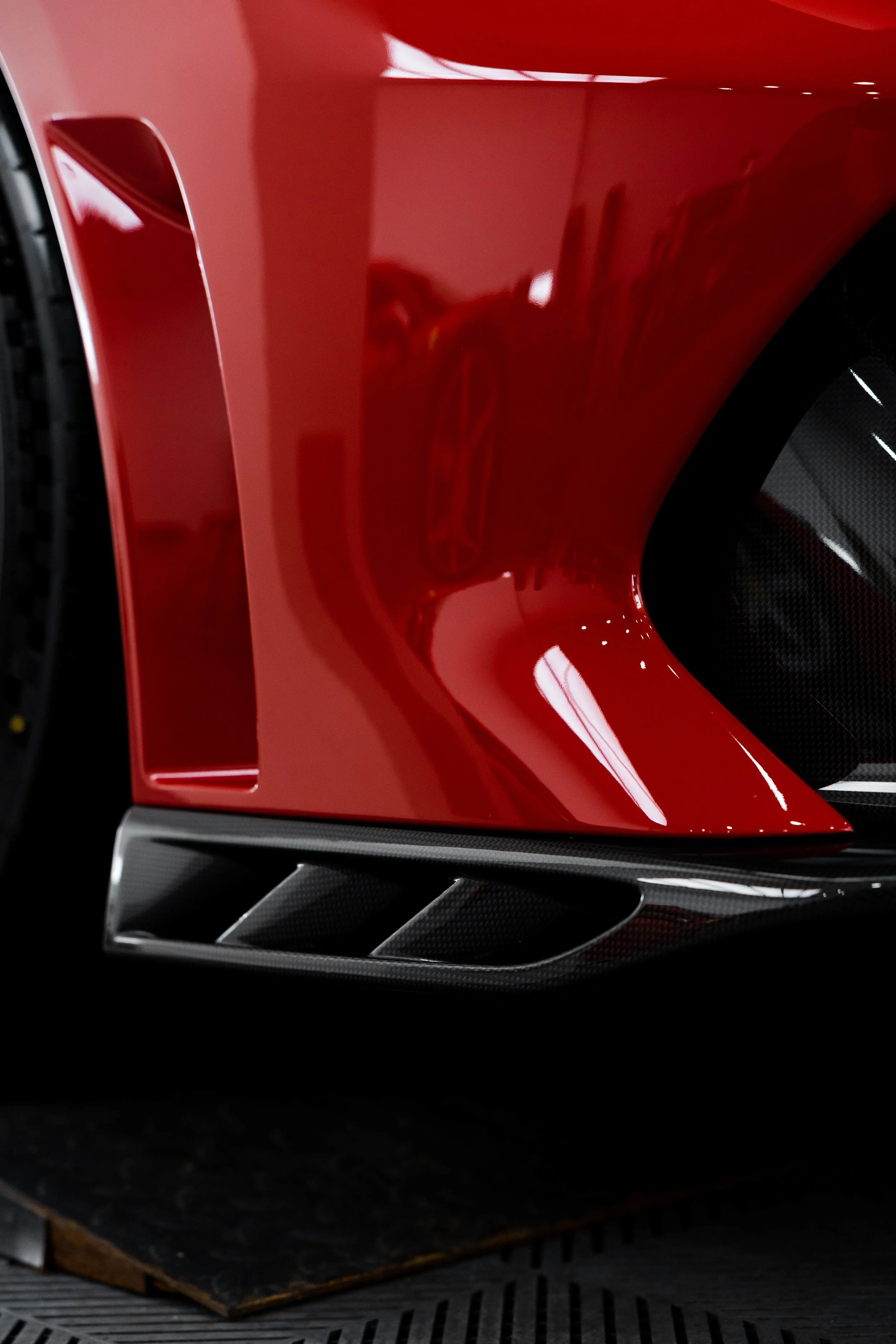 Red Ferrari 296 Speciale front guard vent and carbon splitter detail with XPEL Paint Protection Film in Sydney