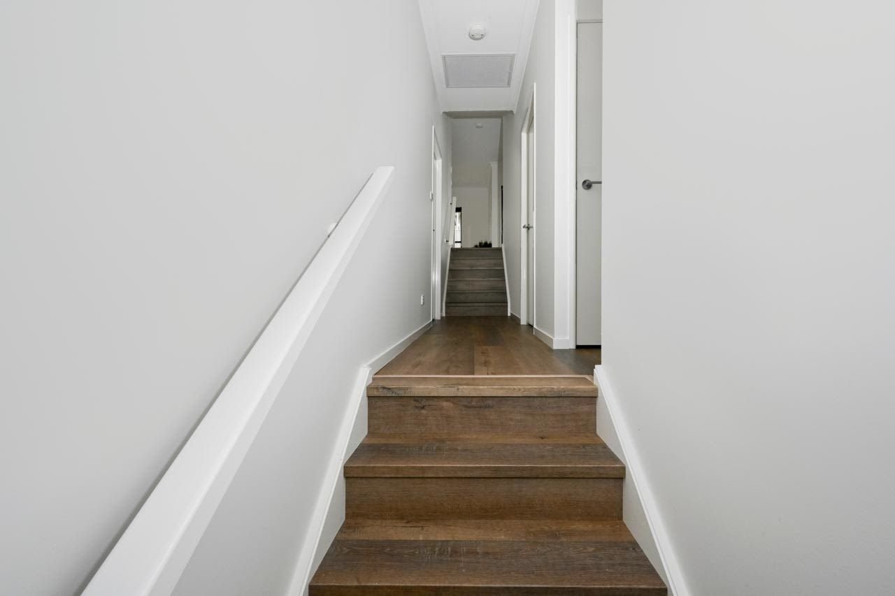 Hallway and steps in split level home with wooden laminate flooring_Carnelian Projects.jpg
