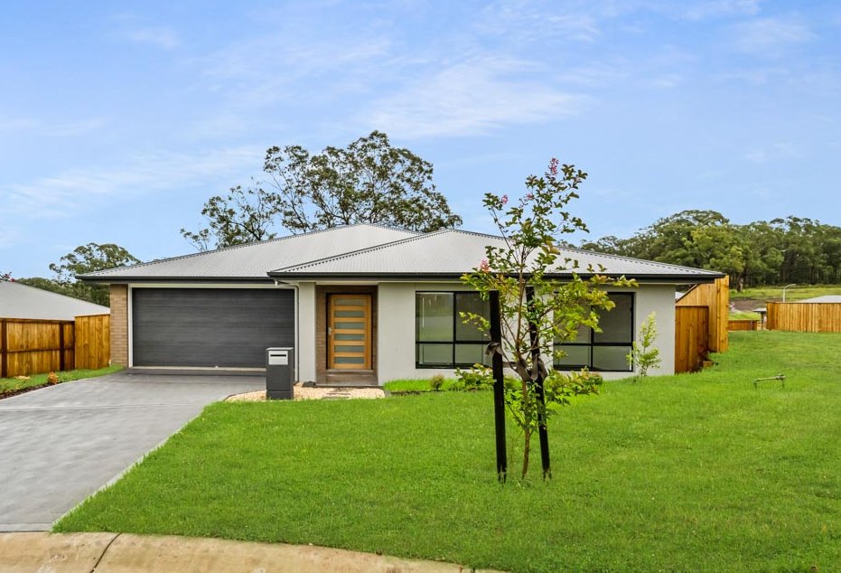 Light grey house facade with wooden front door and dark grey garage door_Carnelian Projects.jpg