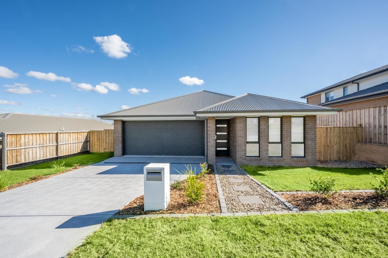 Single storey brick home with dark grey garage door_Carnelian Projects.jpg