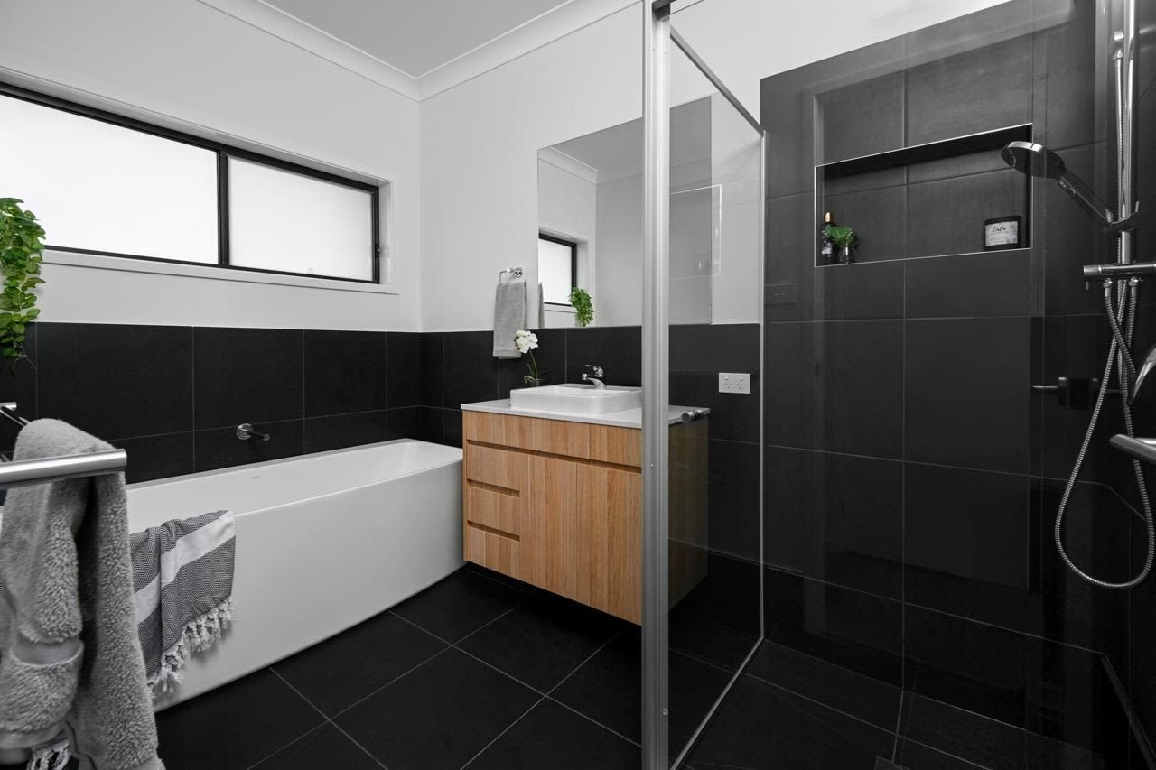 Black and white bathroom with light oak wooden vanity and back to wall bath_Carnelian Projects.jpg