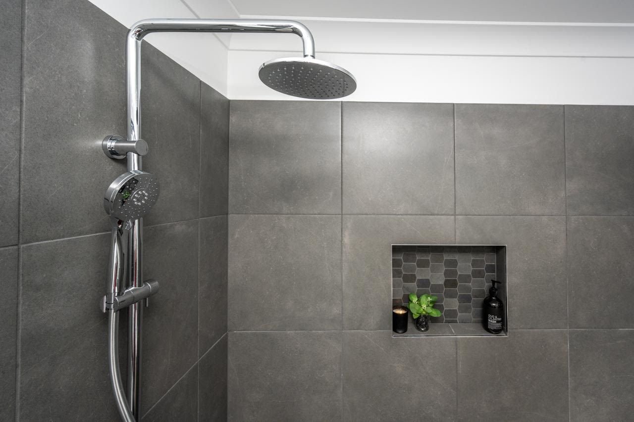 Shower with dark grey tiles, niche and monsoon showerhead with handheld shower rail_Carnelian Projects.jpg