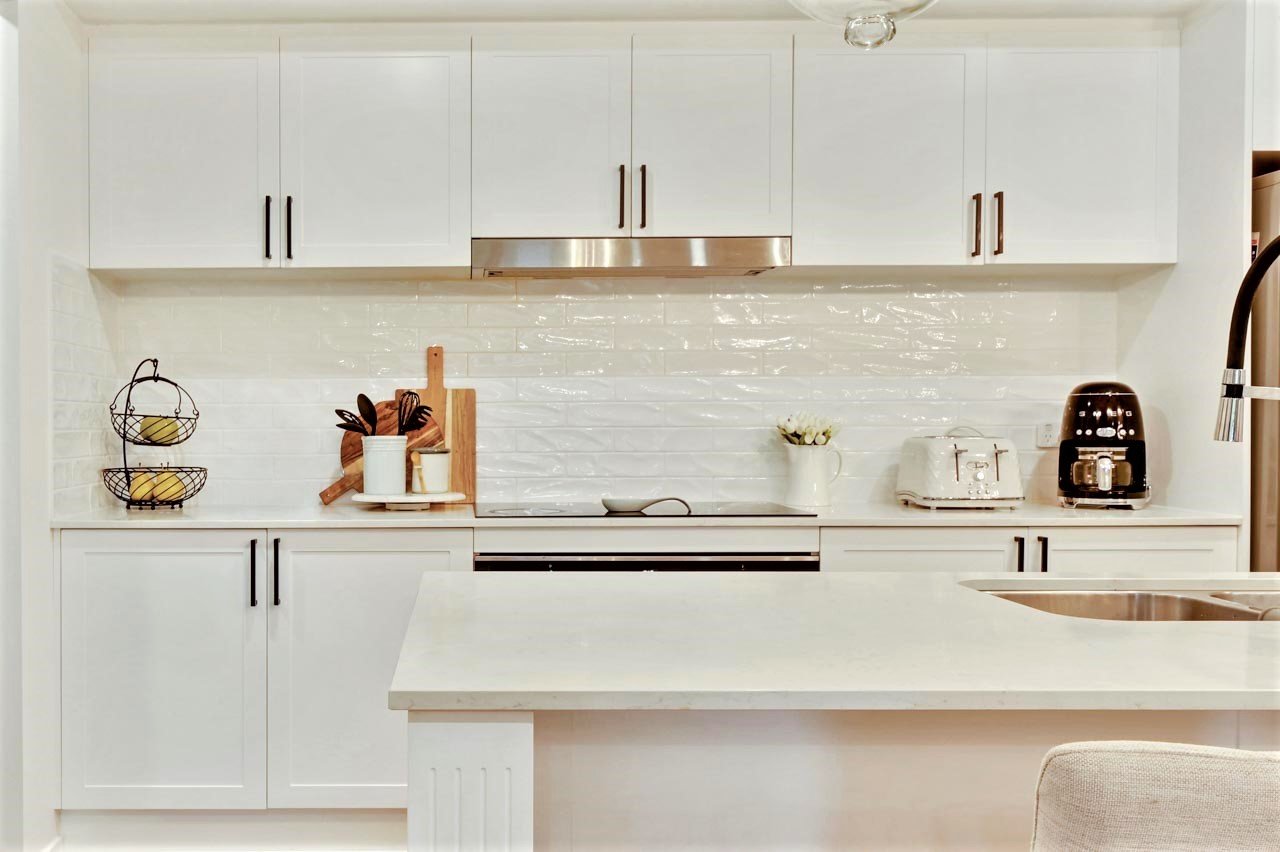 Hamptons style kitchen with white tile splashbak and white shaker cabinetry.jpg