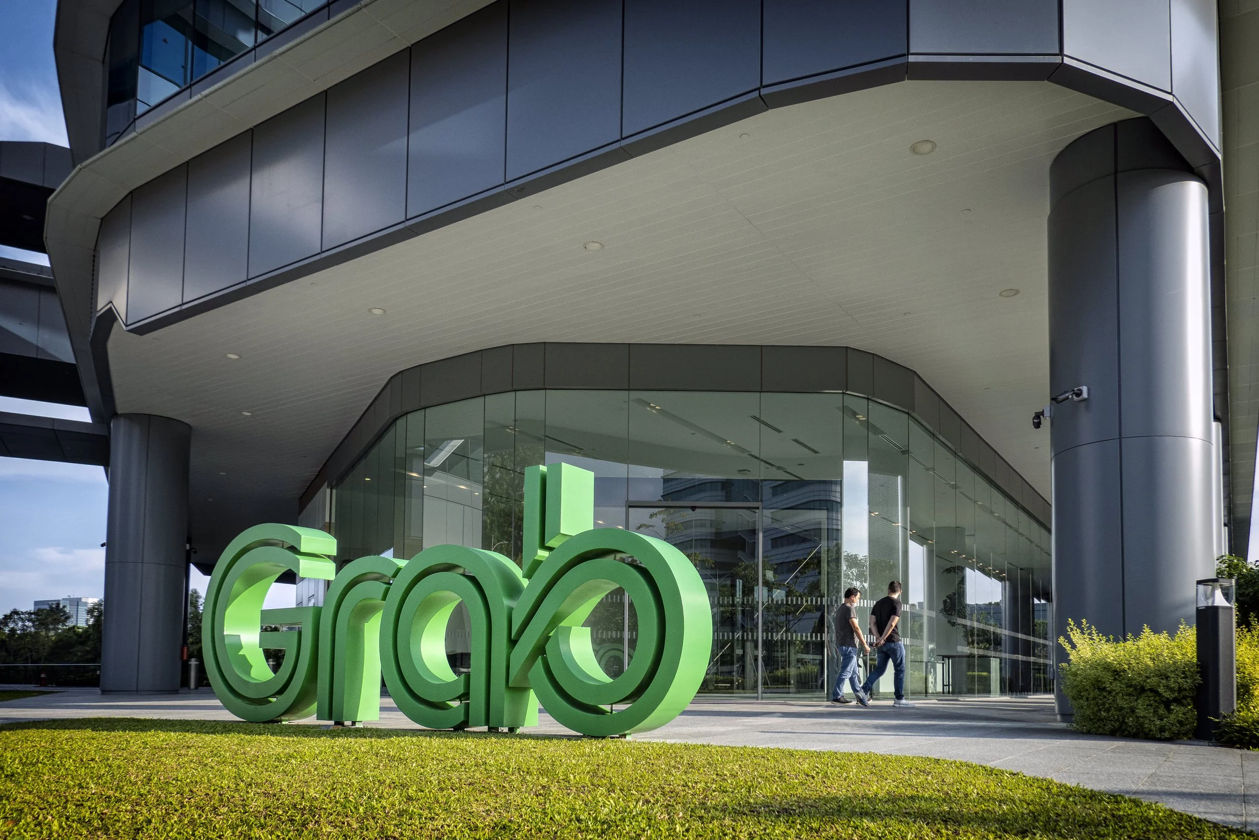 Grab, Singapore office, outside view of the building, two people walking by, Grab logo