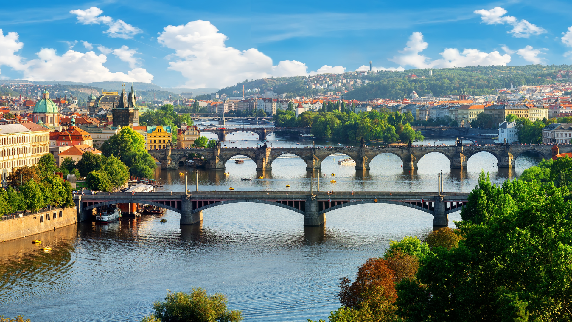 View of Prague, Czech Republic, with the Vltava River and multiple bridges, including Charles Bridge.