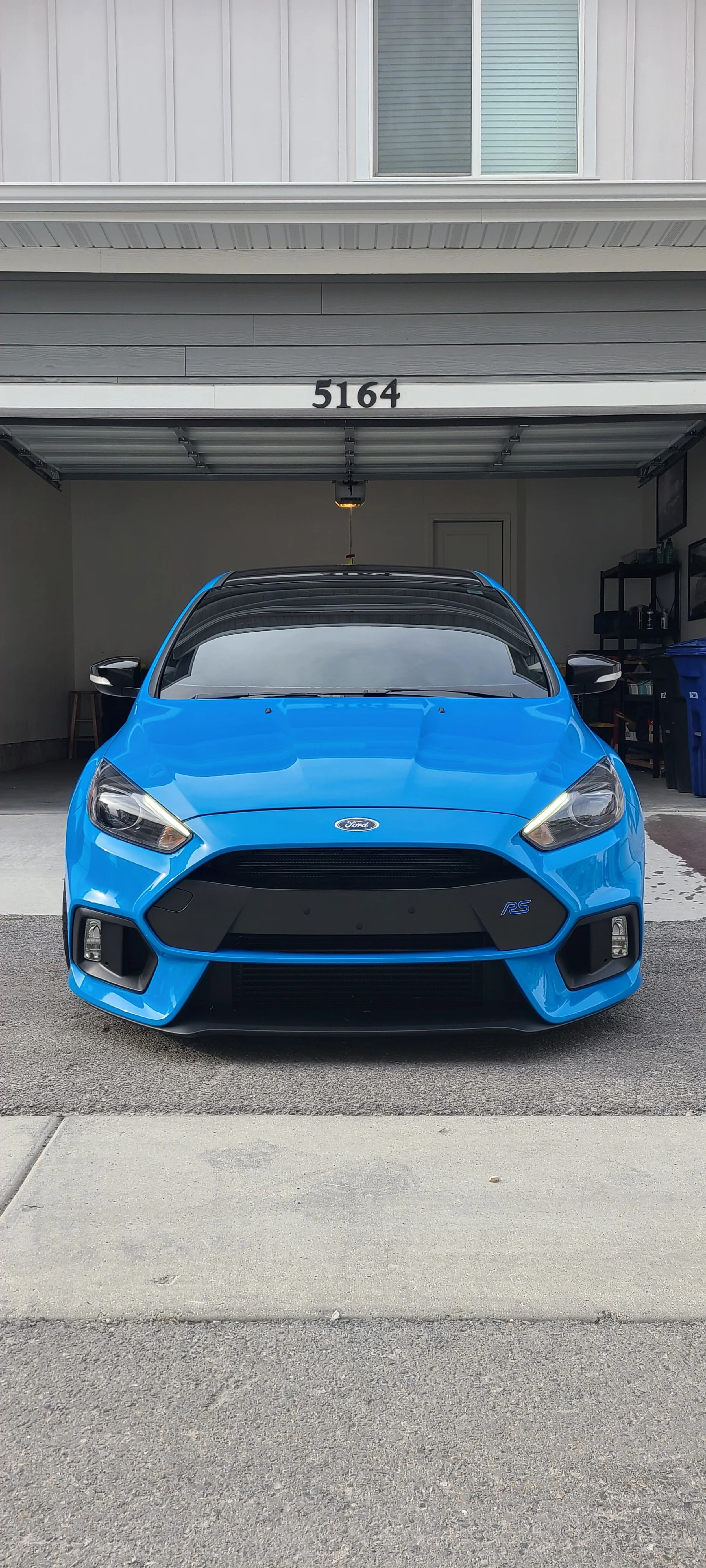 Blue Ford Fiesta RS parked in front of wild detail garage.