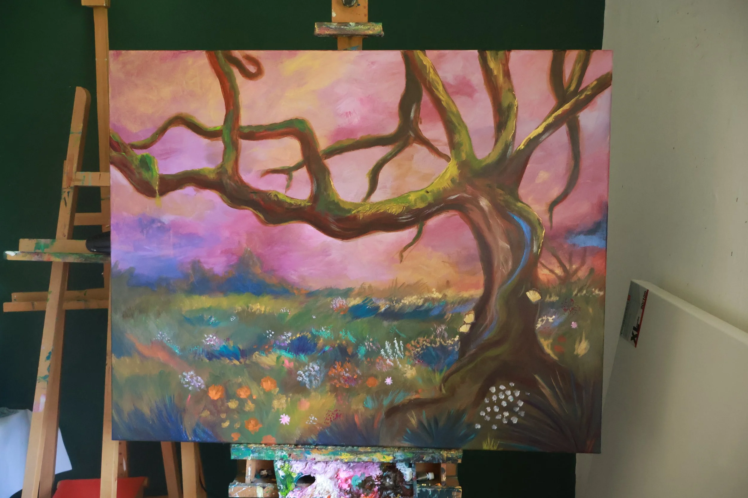 Ein Baum steht in einer wunderwilden Wiese und strahlt in leuchtenden Farben