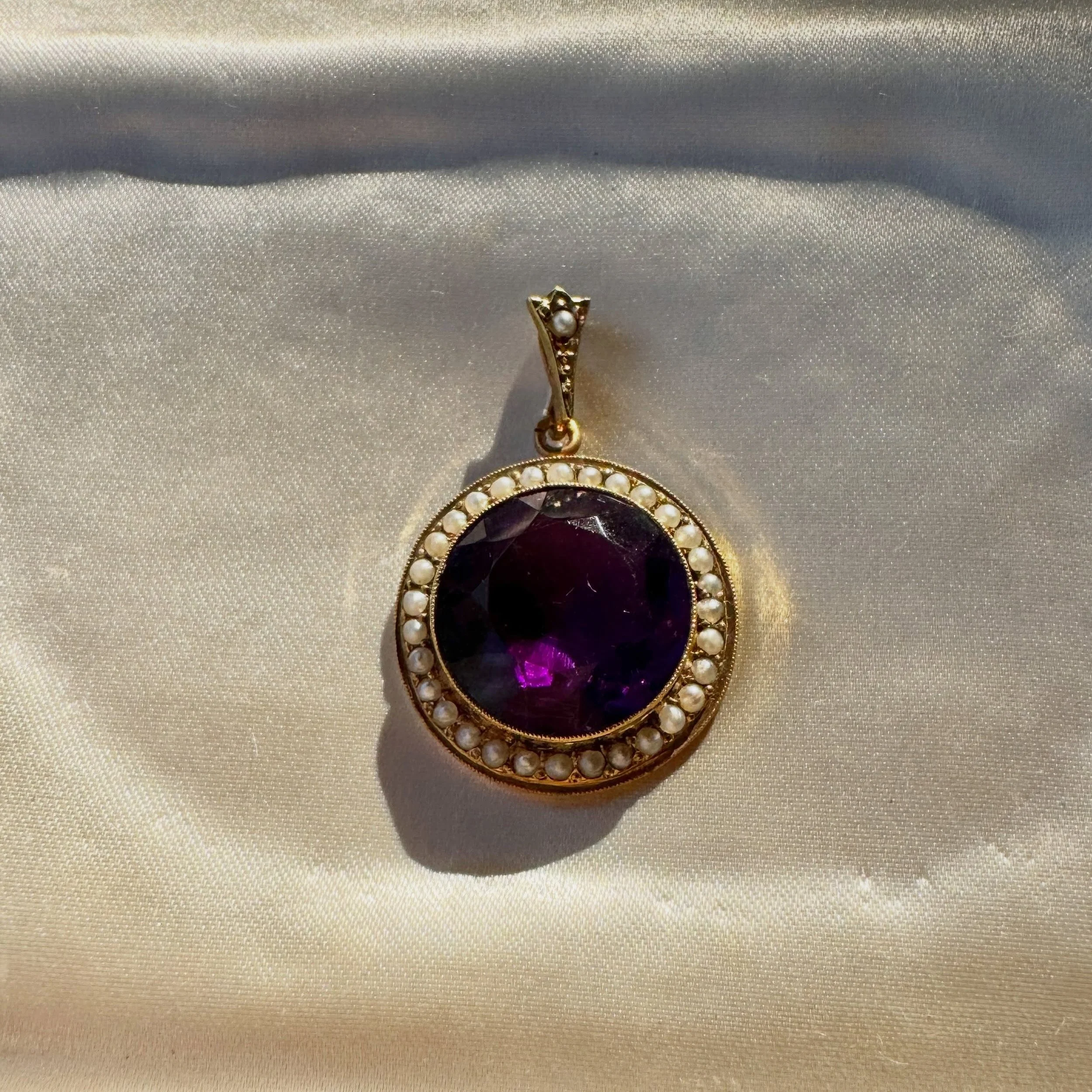 A glowing amethyst pendant with a pearl halo &amp; decorative bail, all set in glowing 9ct yellow gold. This beauty is just big enough this would be a wonderful addition to an antique jewellery collection 💜💜💜
Find it on the website now - I&rsquo;v
