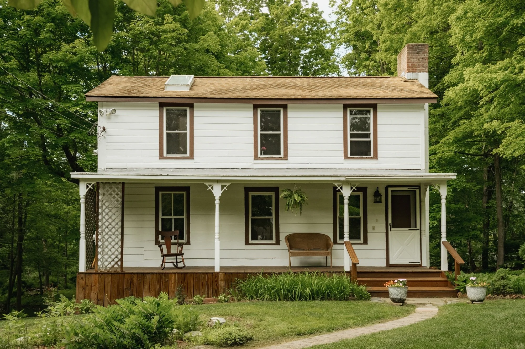 A storybook cottage by the creek. Built circa 1830, this charming 2-bedroom home is full of original character, from wide-board floors and exposed beams to a rocking-chair front porch made for slow mornings. With 450 feet of the Saw Kill Creek flowin