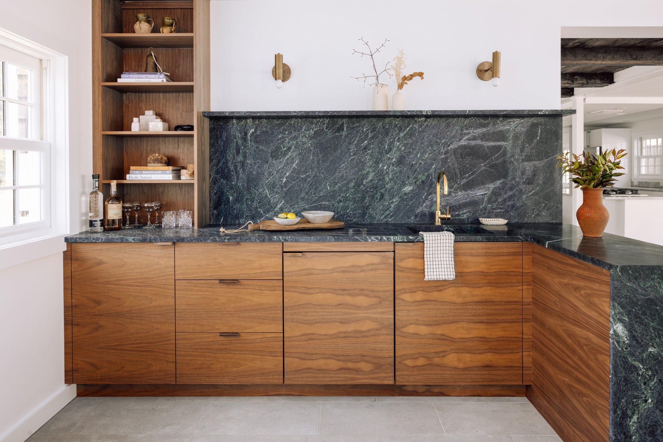 Kitchen with wooden cabinets, green marble countertop and backsplash, white walls, and minimal decorative items.