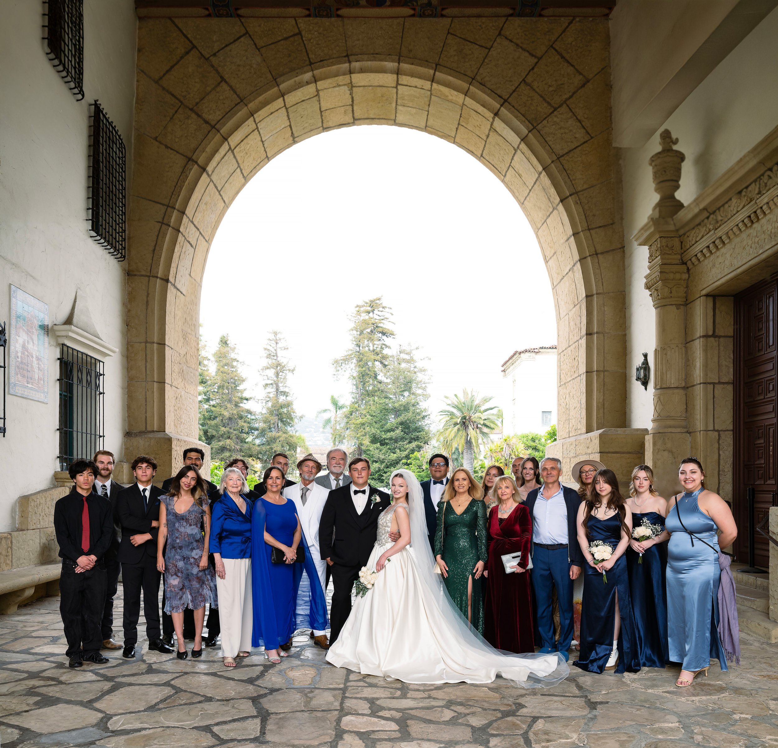 The wedding party stands in the iconic arch of the SB court house