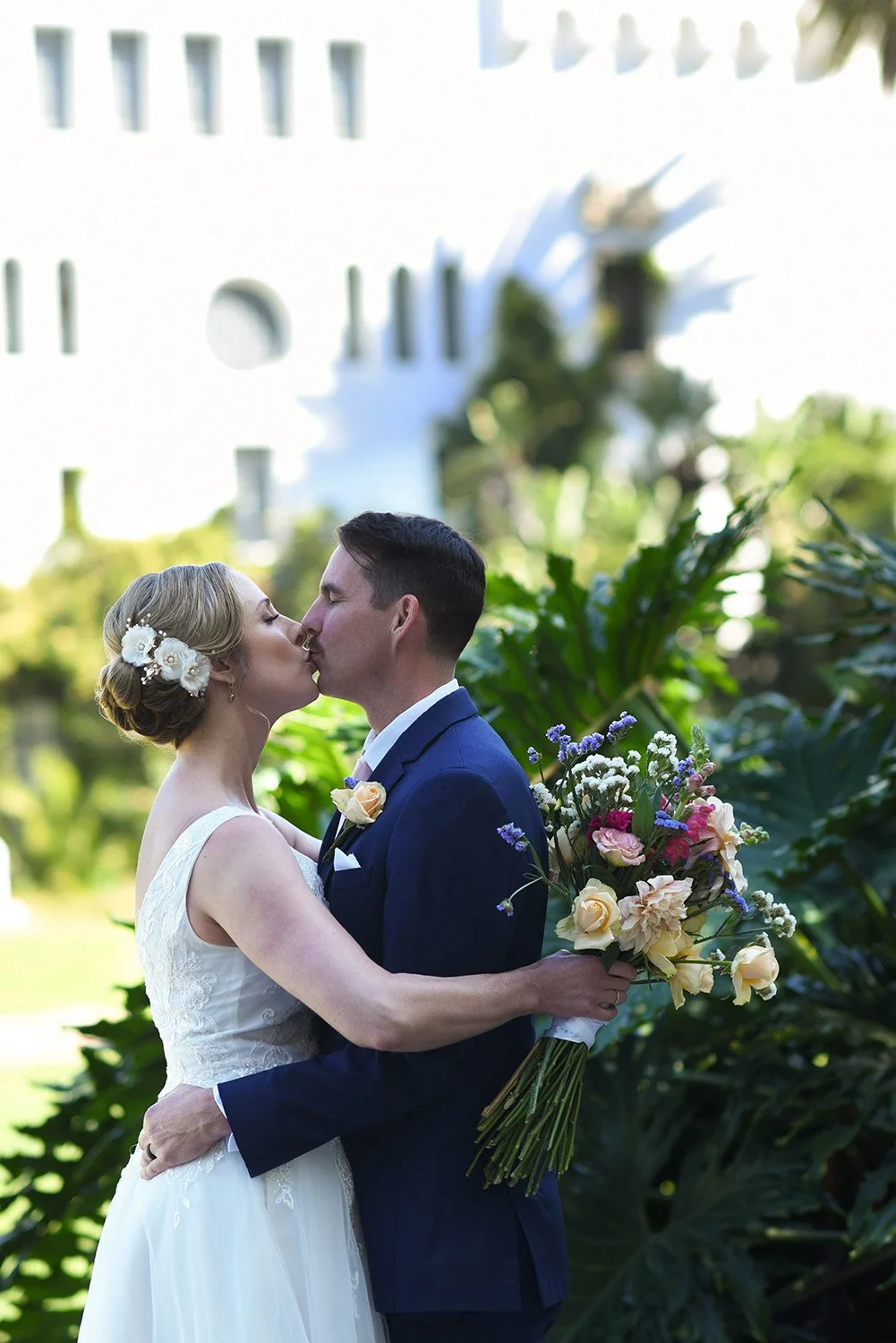 Set with the historic Santa Barbara courthouse gardens, a newly married couple kiss