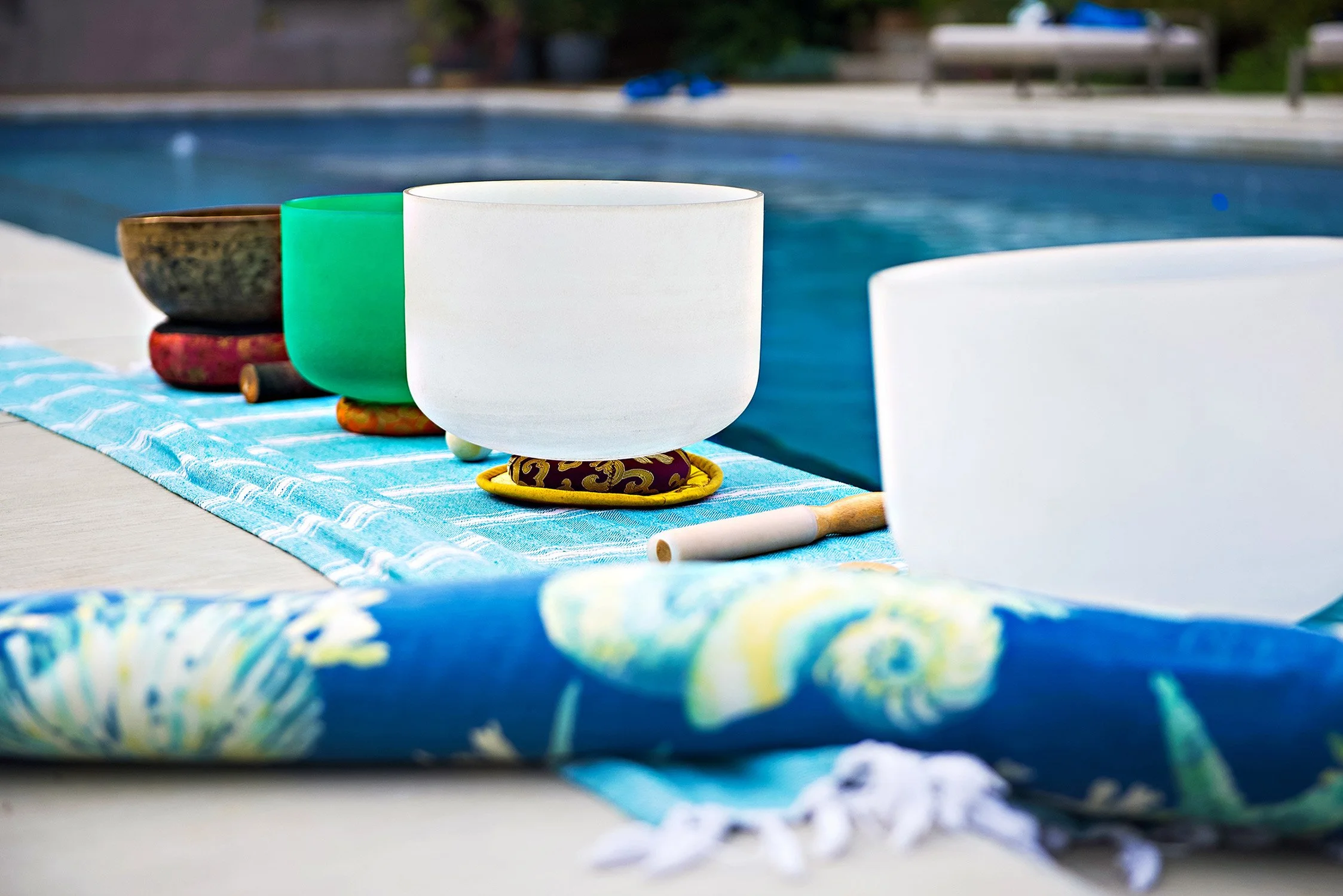 handmade mats sit pool side with singing bowls
