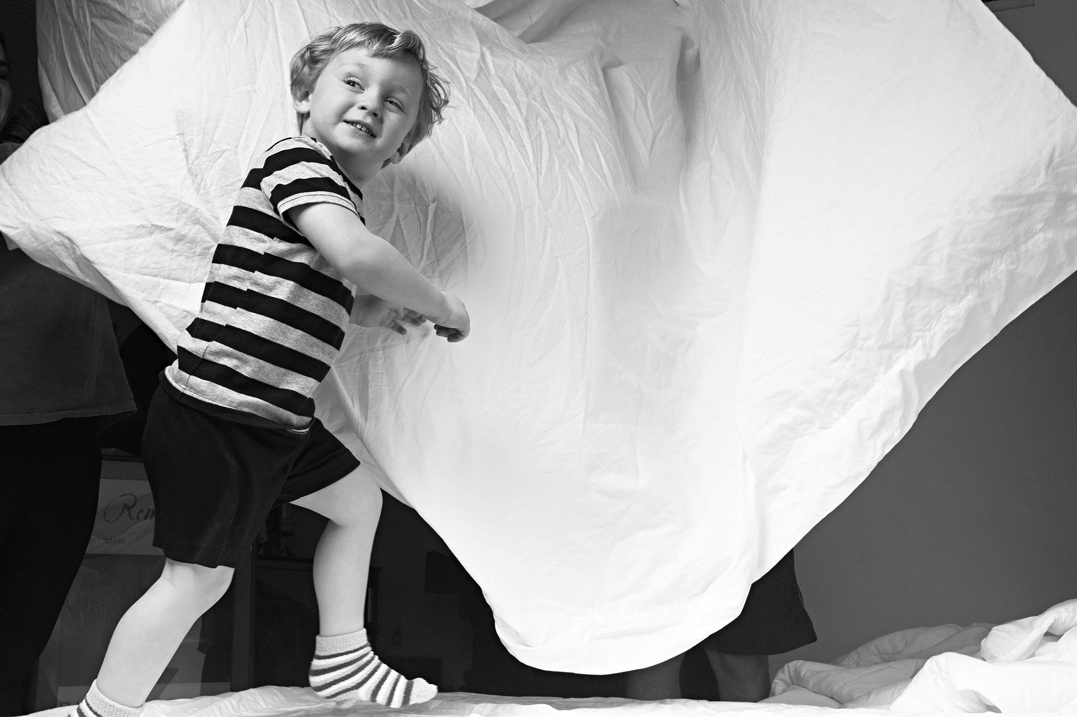 Feather bed photo shoot with young boy and family