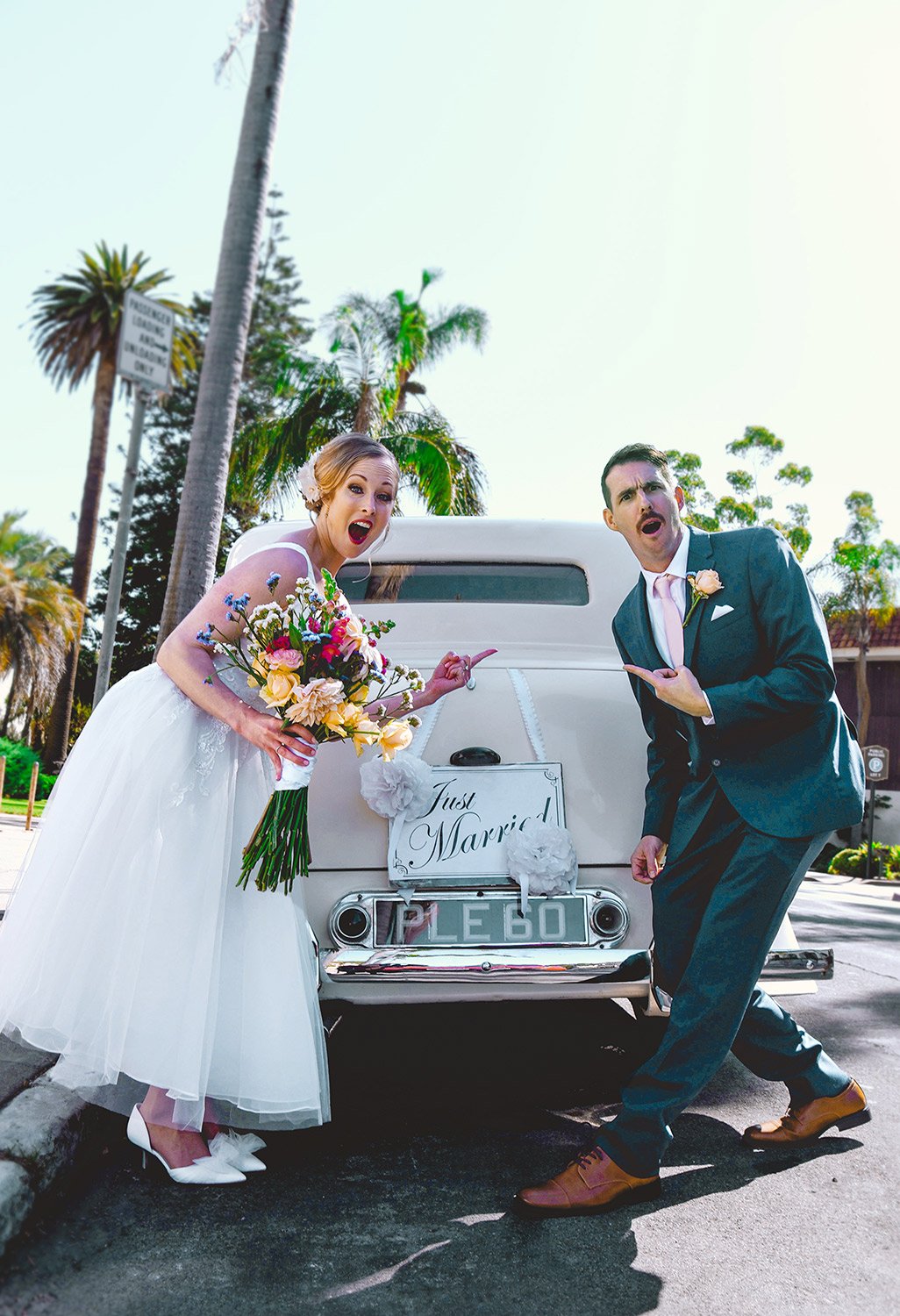 Playful newly weds point in disbelief at each other that they were just married