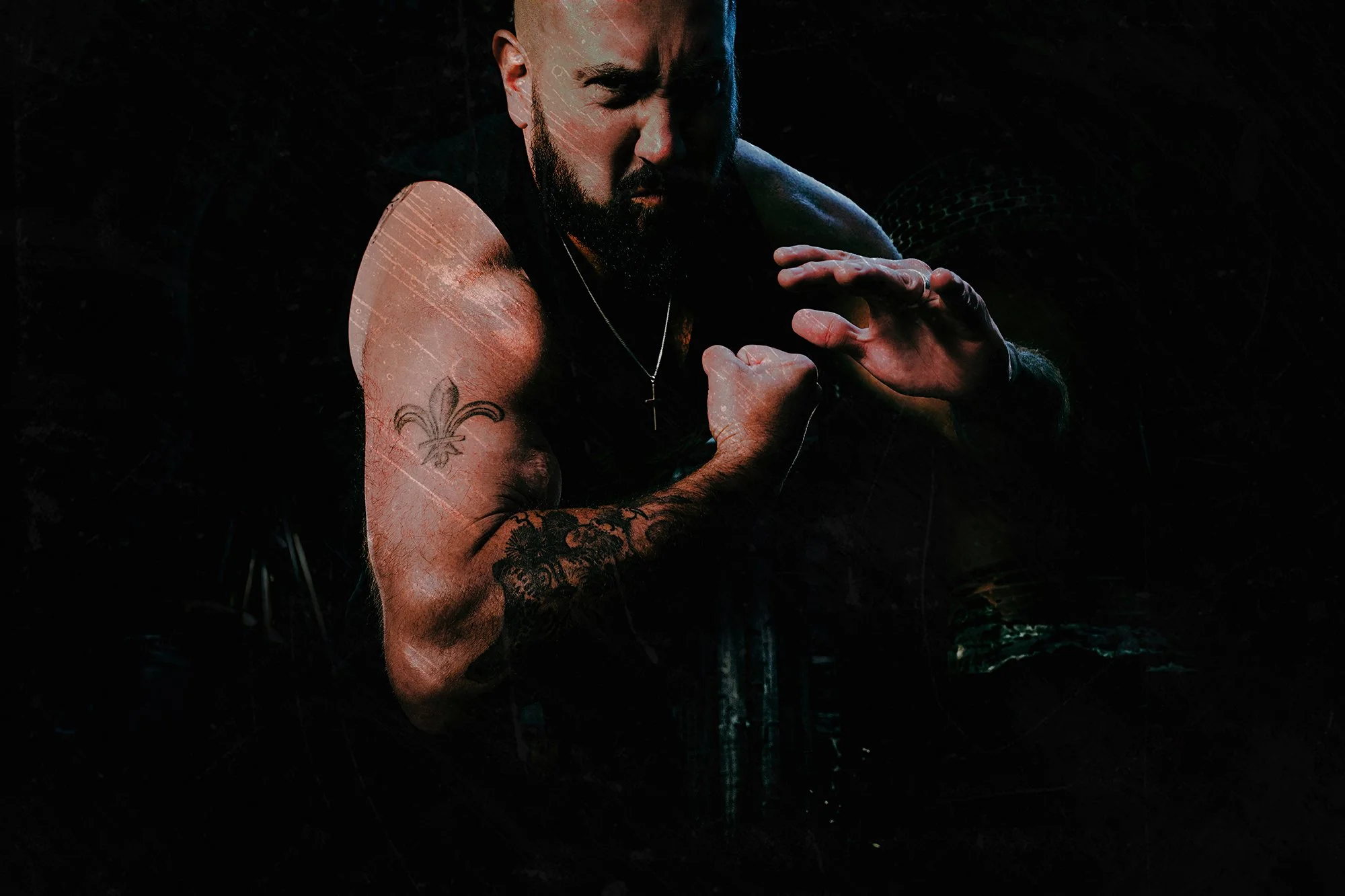 Dark style portrait of male death metal band member performing in dramatic shadows.