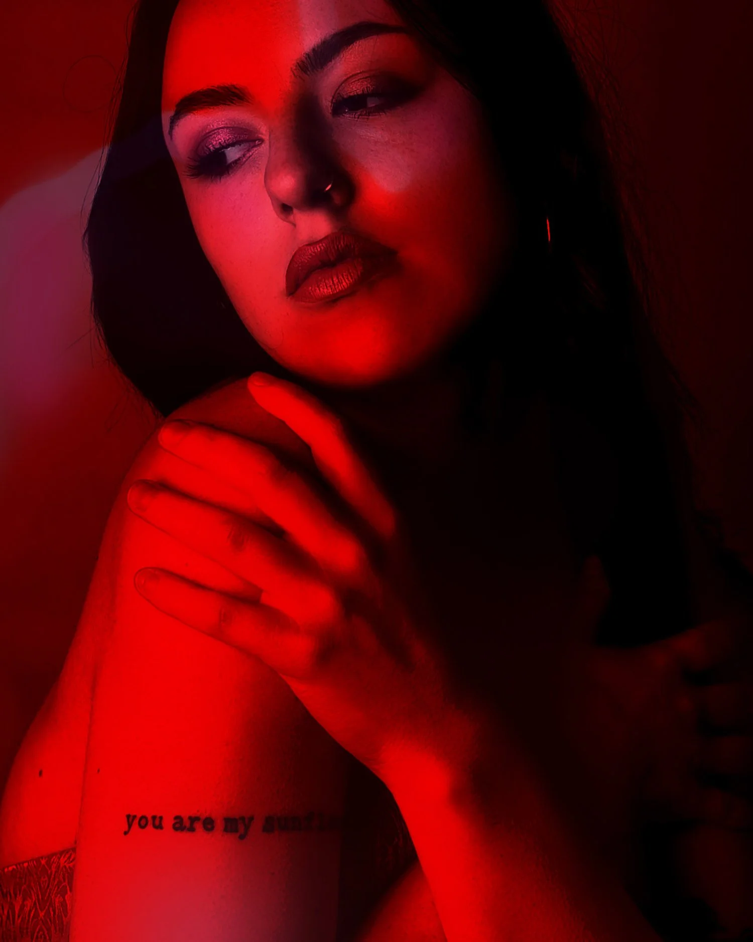 Singer song writer basks in red light for a moody portrait
