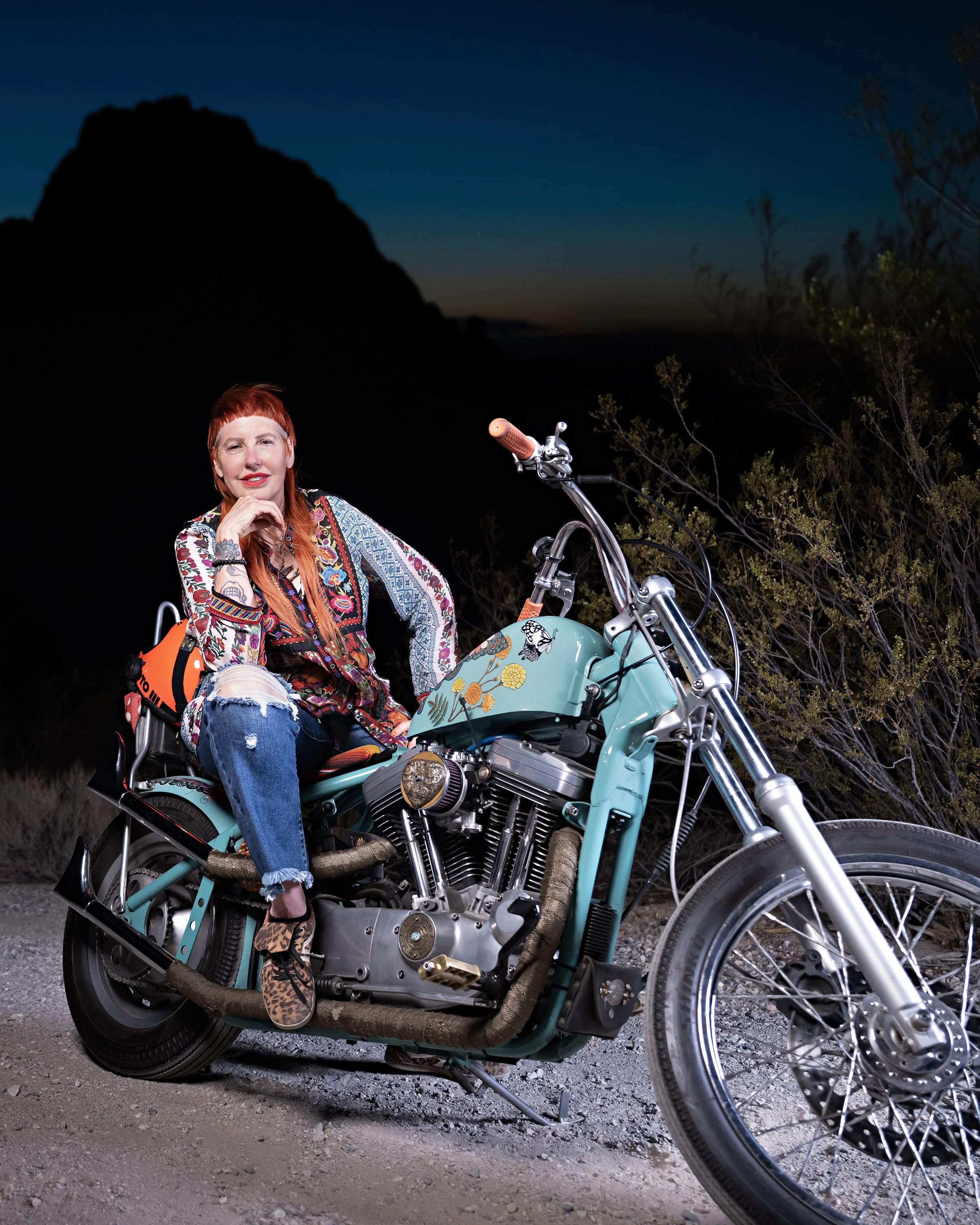Close-up motorcycle photography of Katie Loftus, founder of Ride to the Warehouse, showcasing chrome details on a chopper bike at twilight