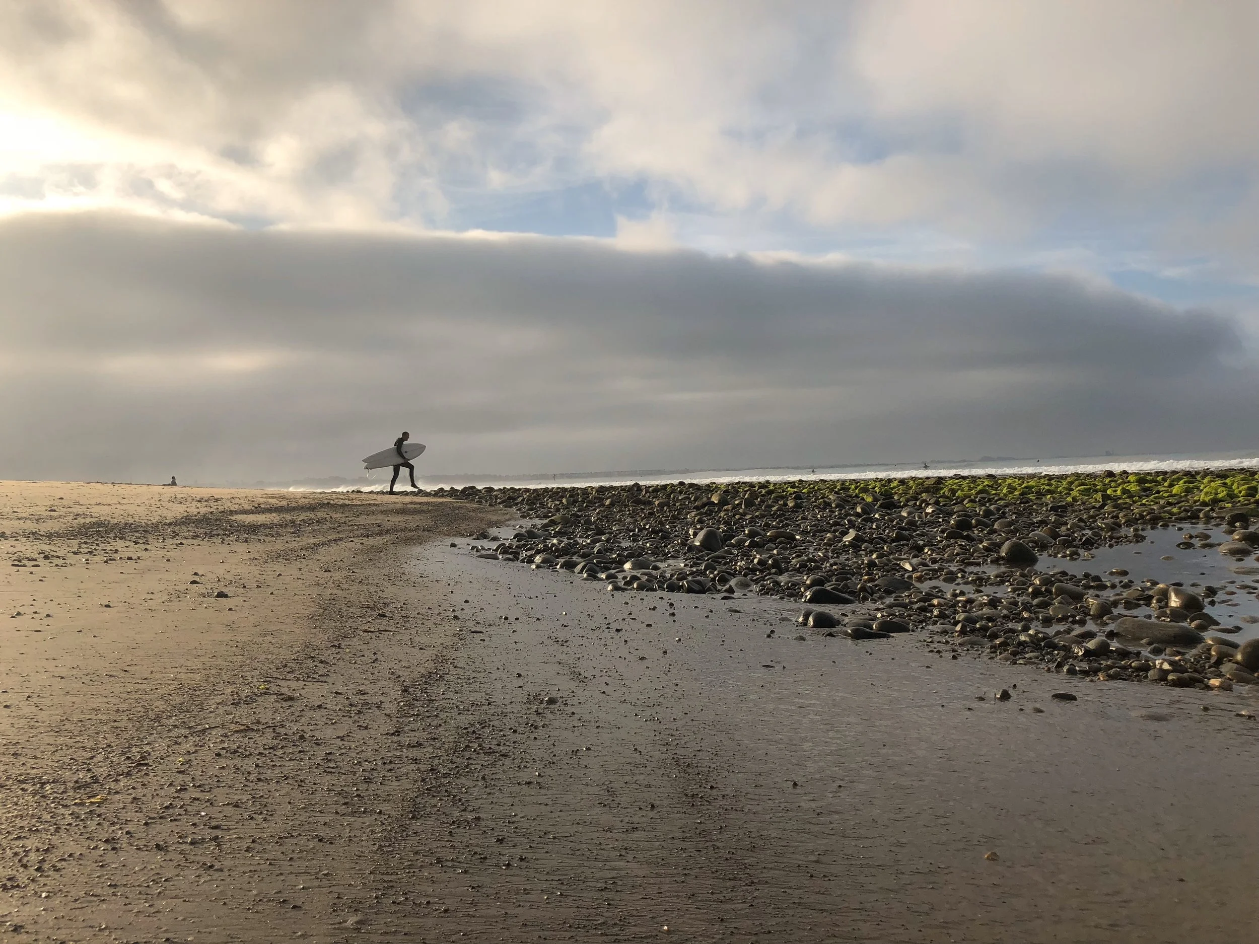Surfer heading out during winter swell, Ventura ca