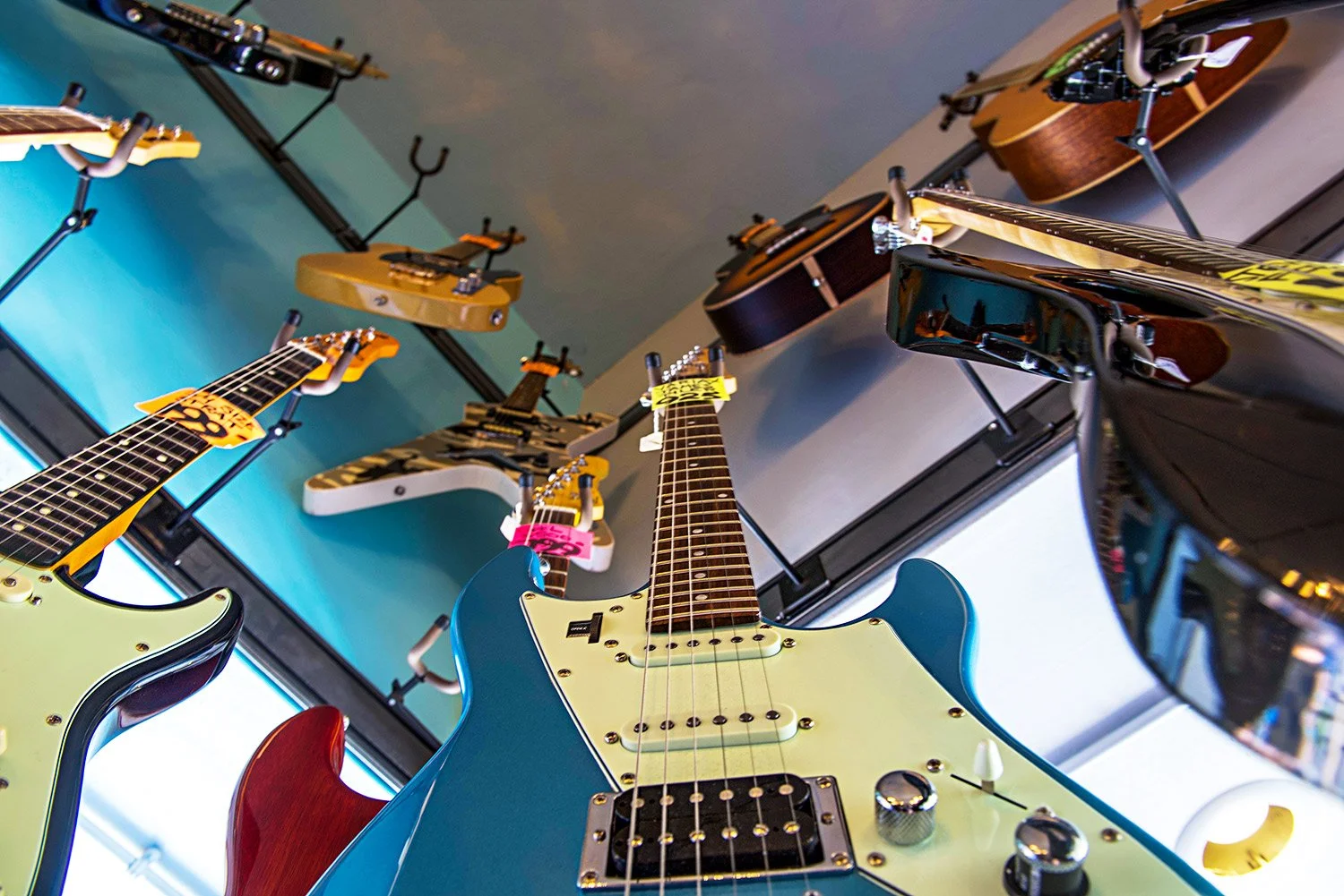 low angles of Guitar 48's inventory hangs on the walls of the retail store Ventura