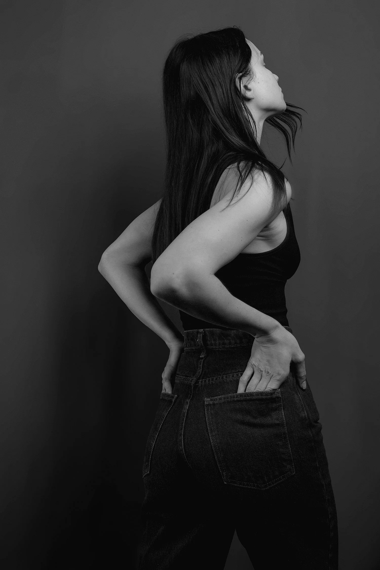 models faces the wall with her hands in her back pockets, photo shoot