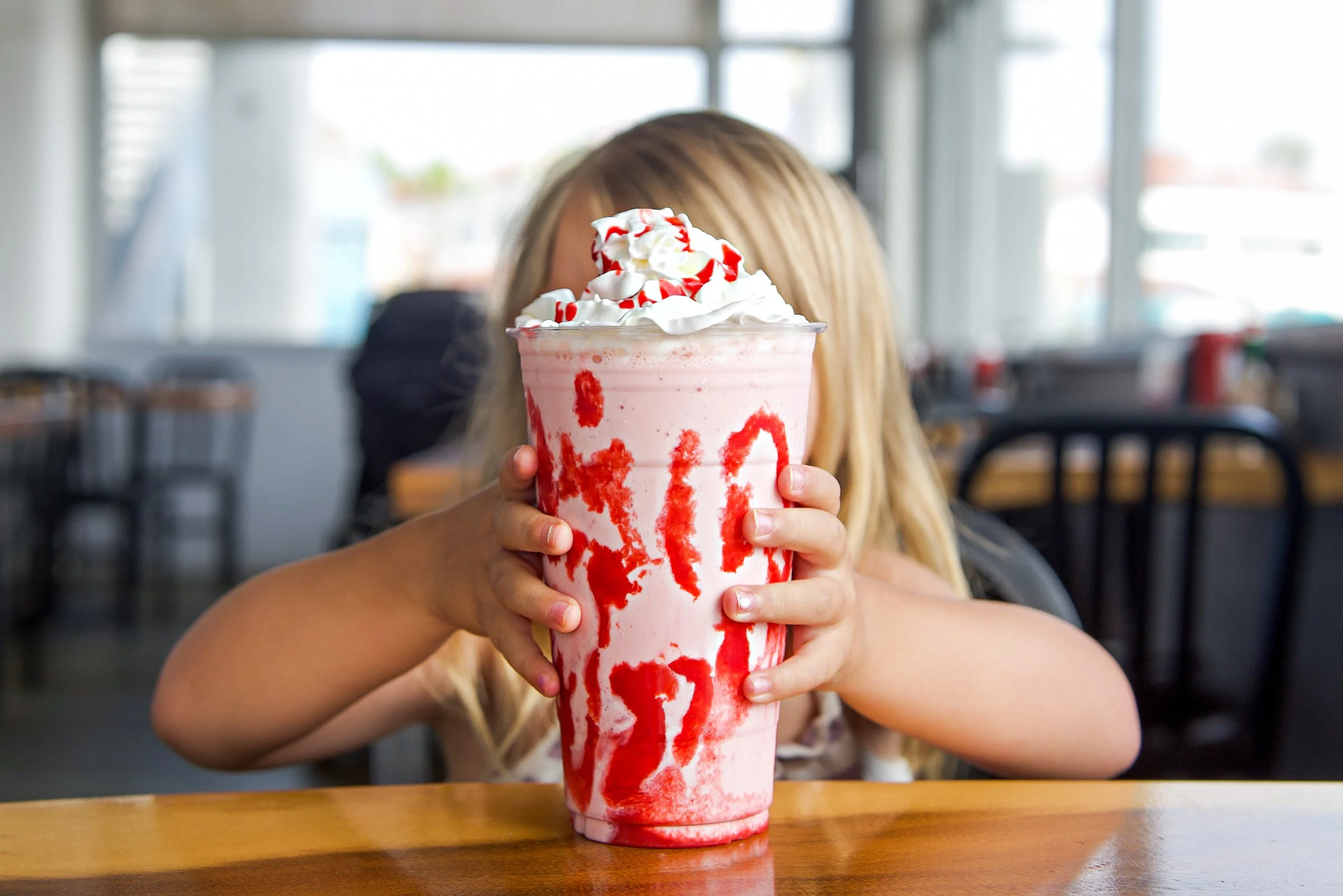 Child reaches for large milkshake at On the Alley.