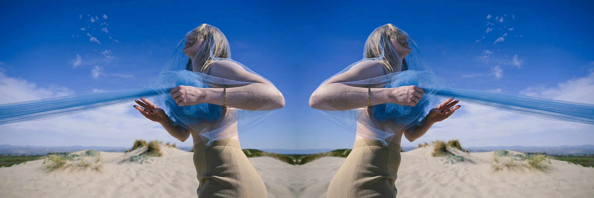woman with blue fabric at the beach