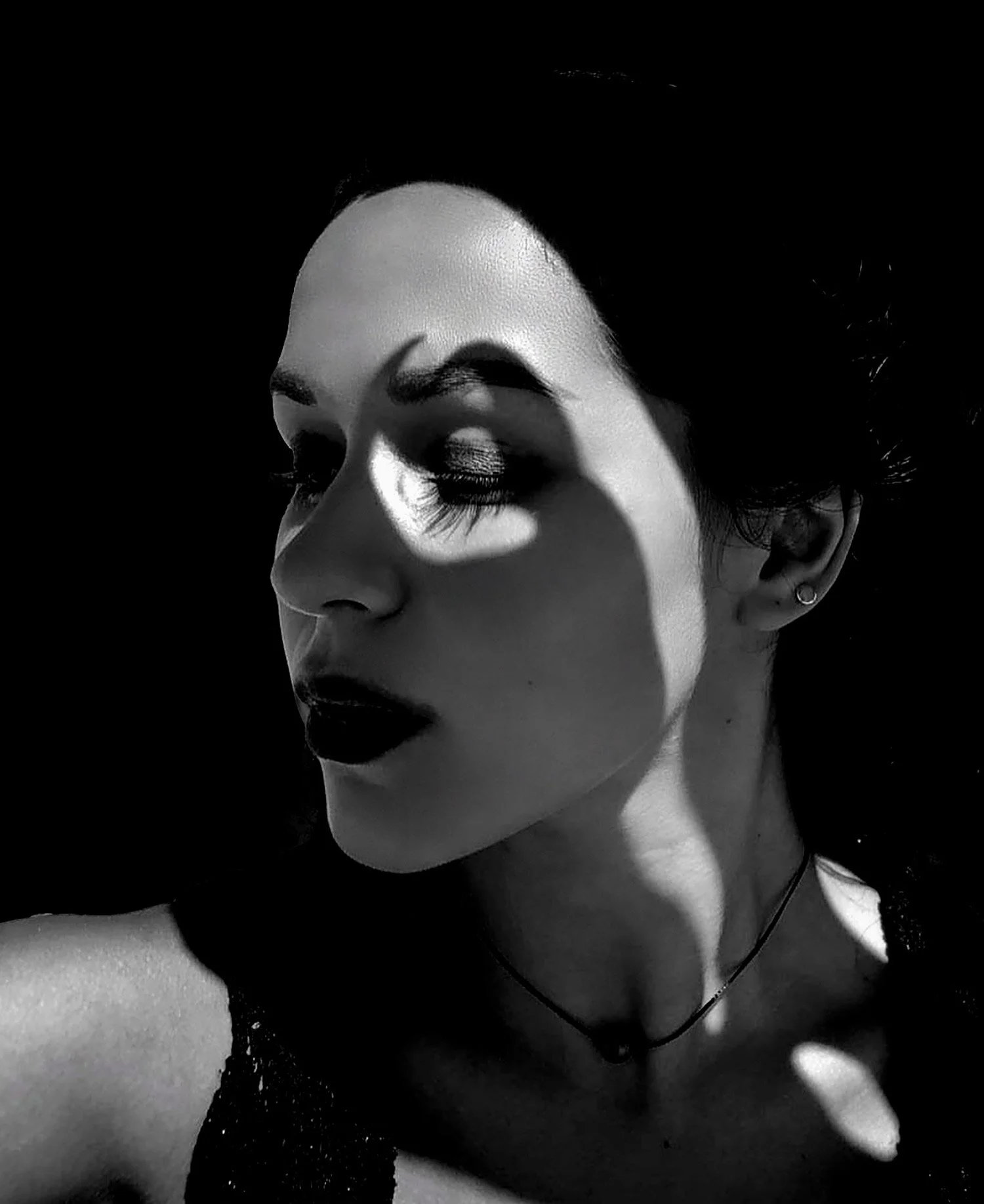 Female creative headshot with dramatic light and shadow play