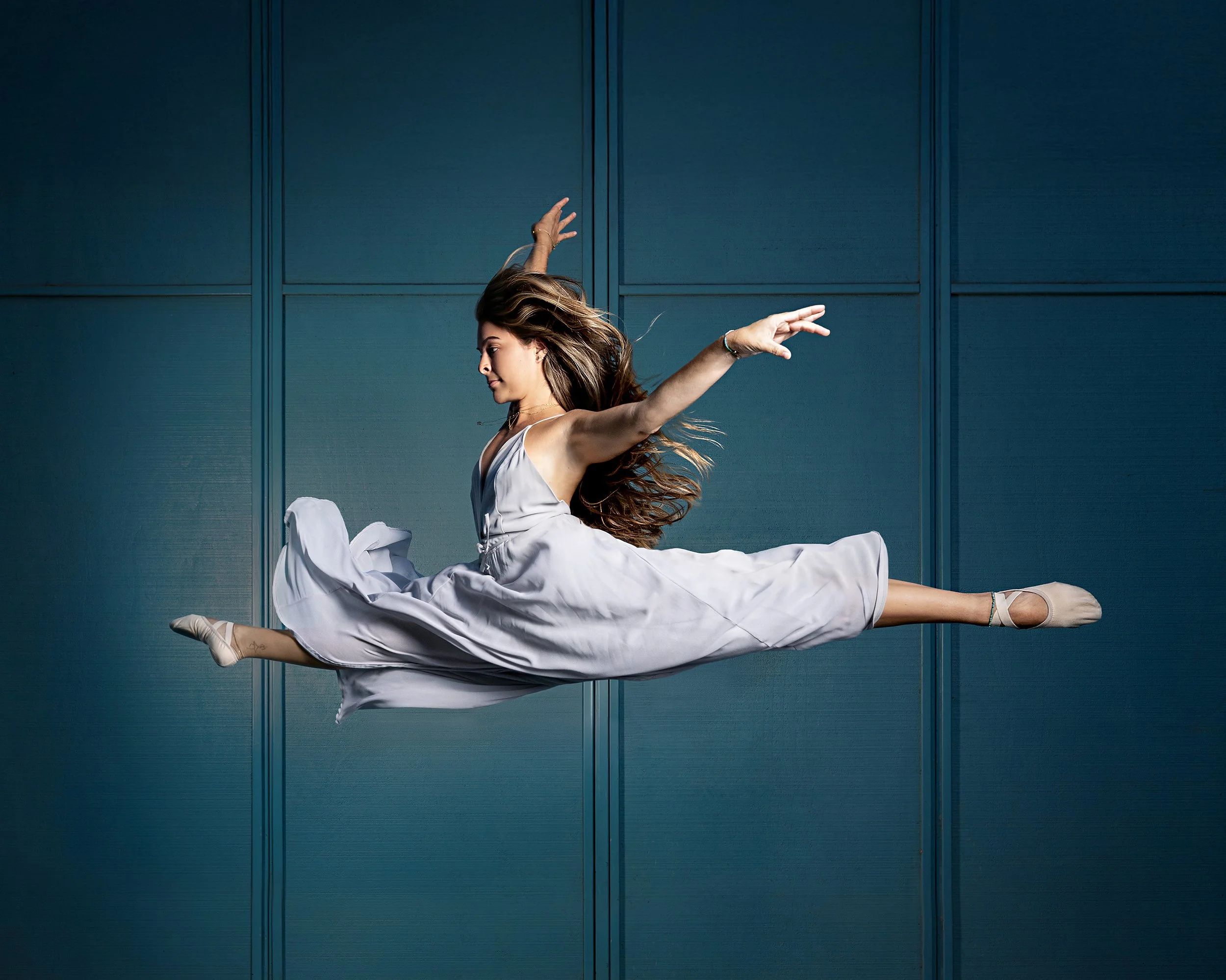 Freeze frame on dancer leaping in a flowy dress