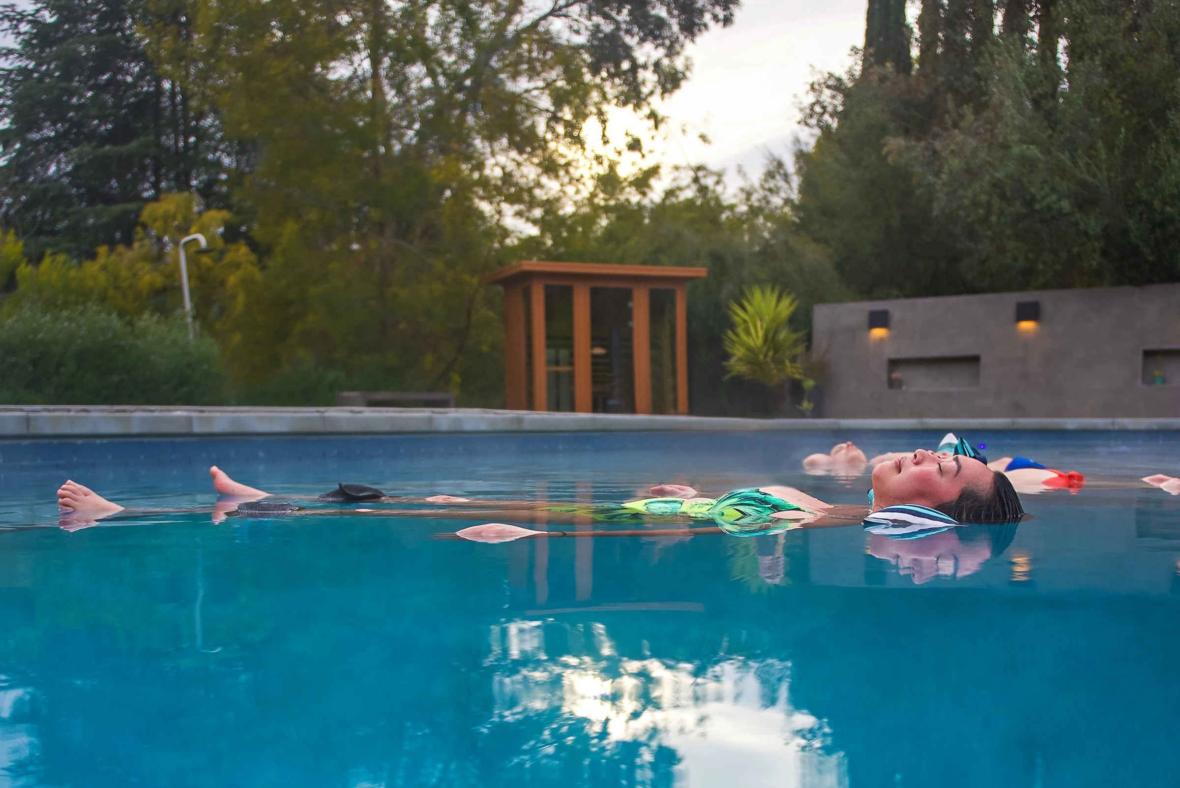 clients floating in a luxury outdoor pool during a water release therapy session