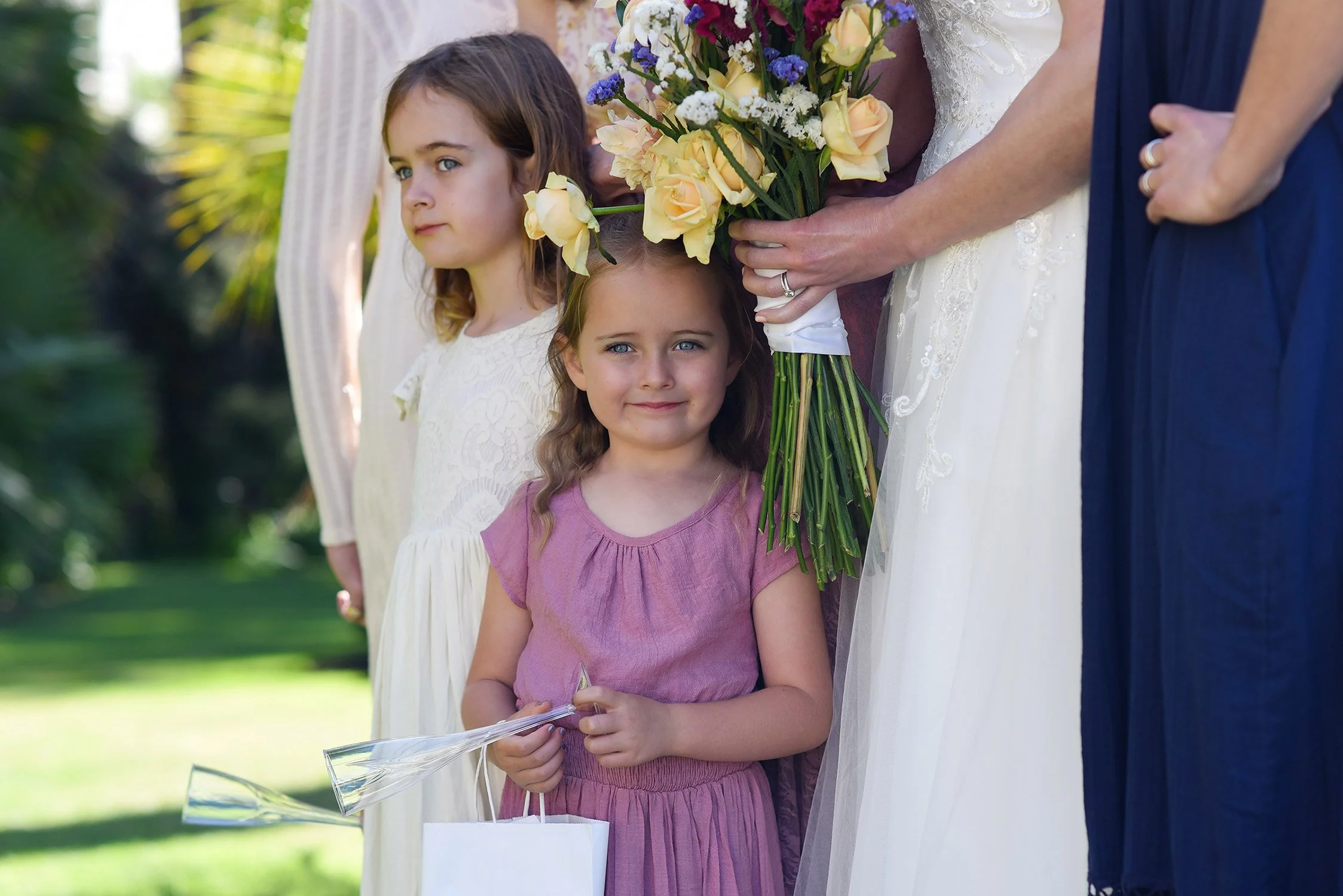 Young flower girl watches the ceremony and smiling