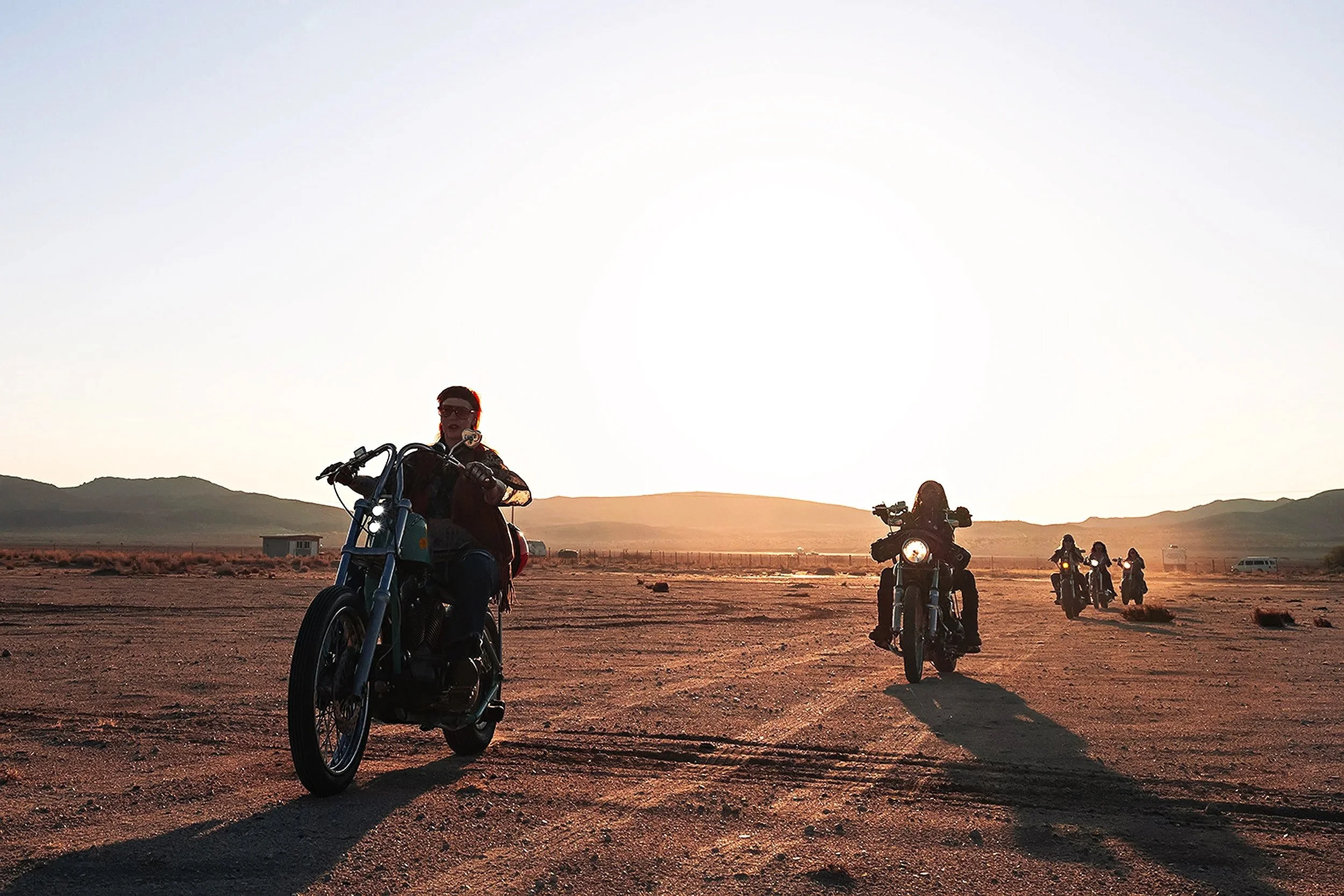 Motorcycle photography of riders on a winding mountain road at sunset