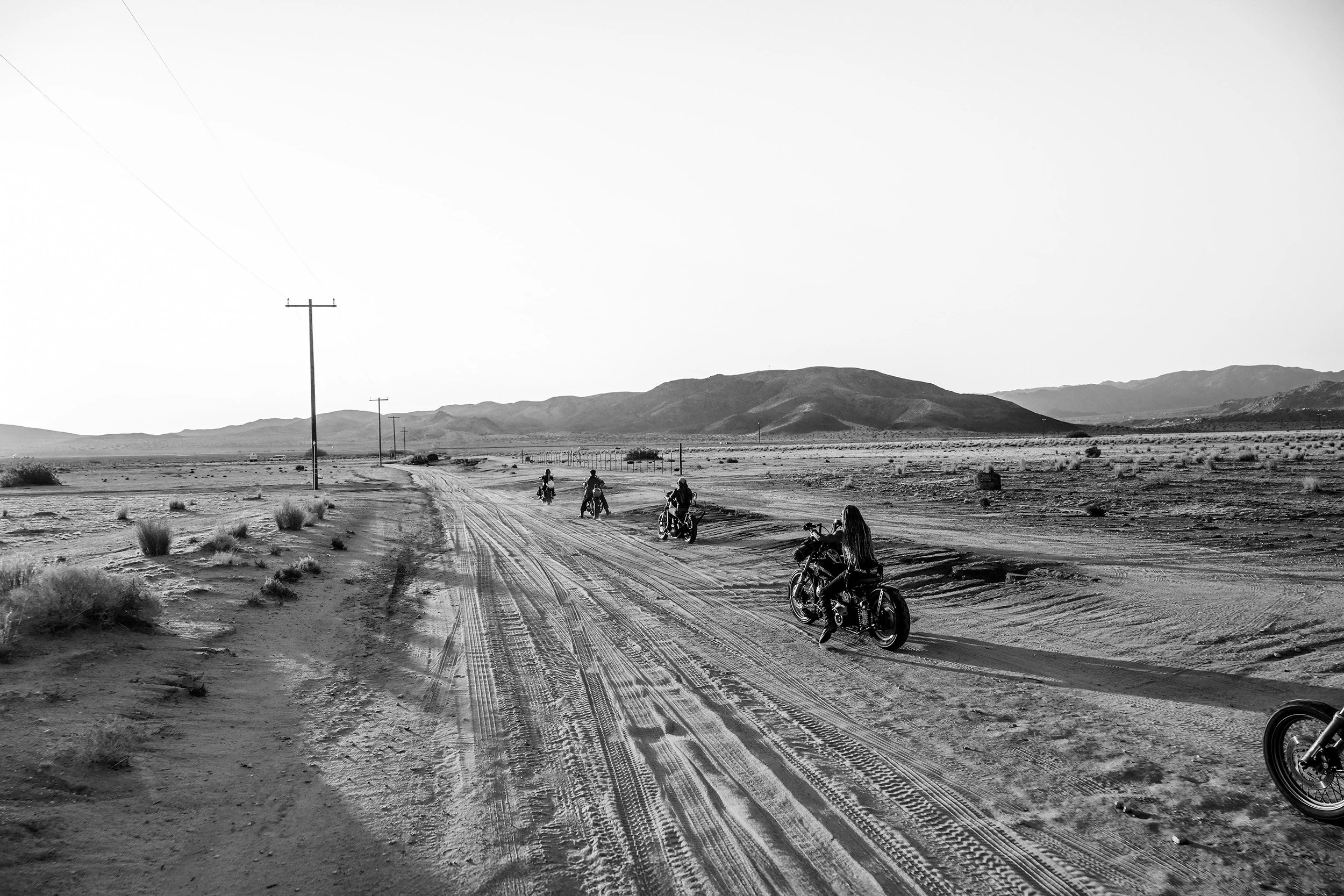 female riders head towards the sunrise in the dessert