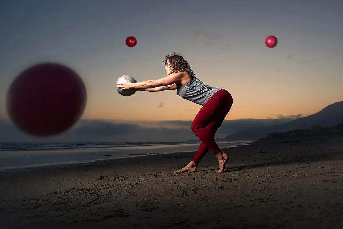 Yoga instructor in red pants stretching on the beach