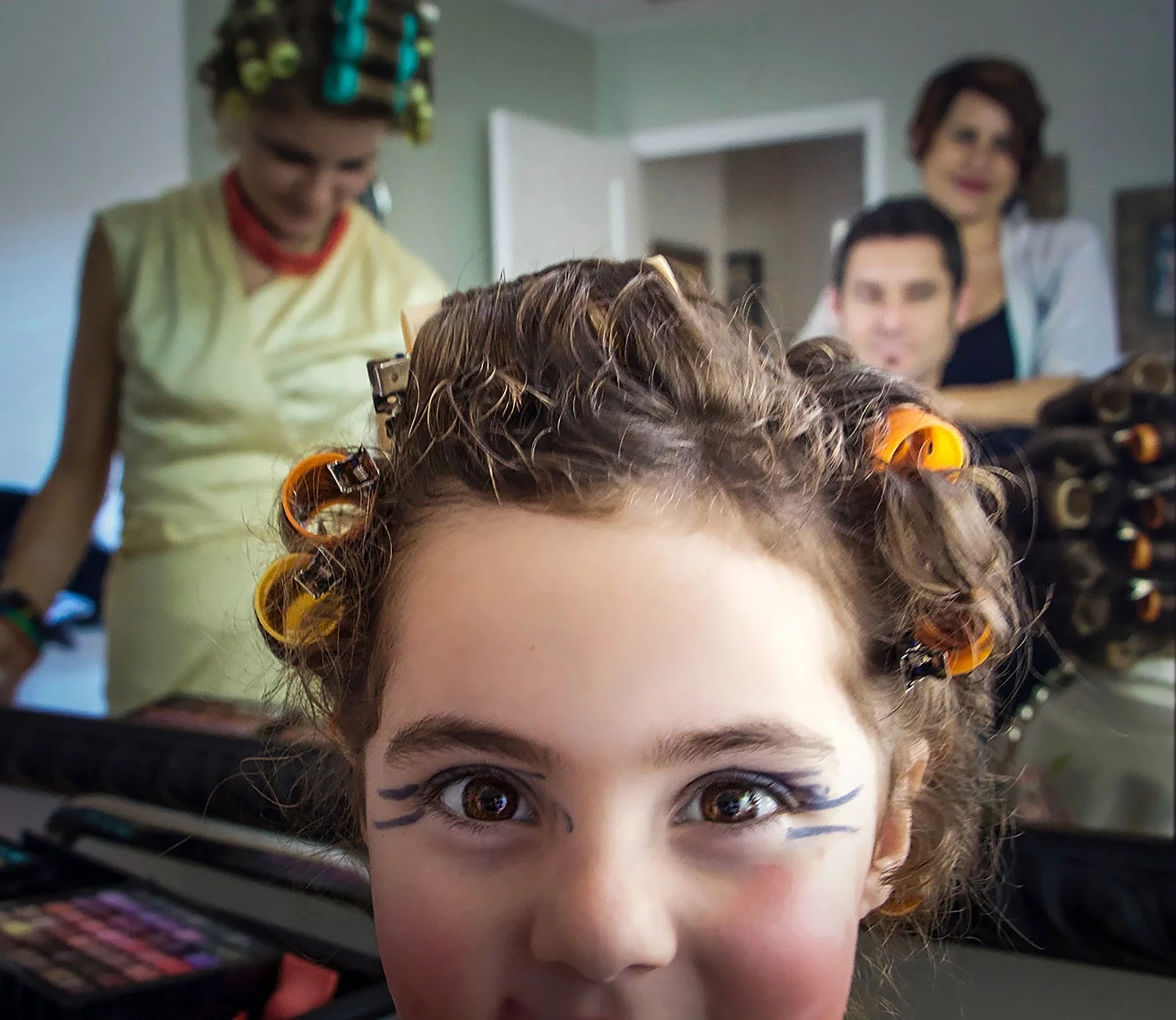 Family photo shoot with the daughters playing dress up with rollers in their hair and make up
