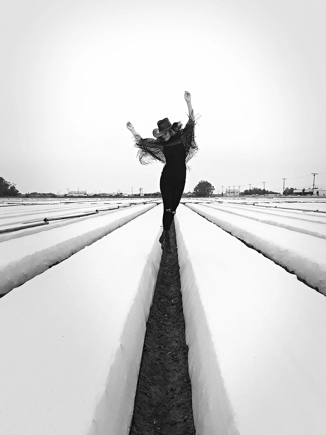 Woman dances down a field of irrigation in Ventura California