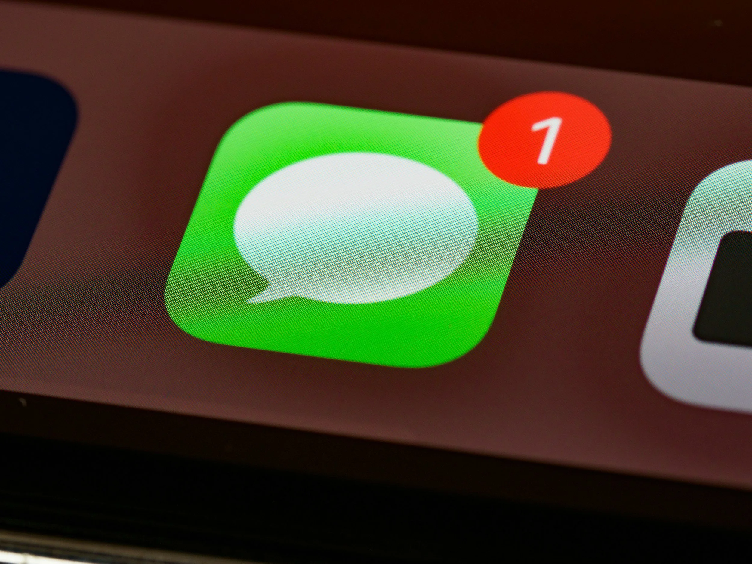 Close-up of a smartphone screen showing the WhatsApp icon with a notification badge indicating 1 new message.