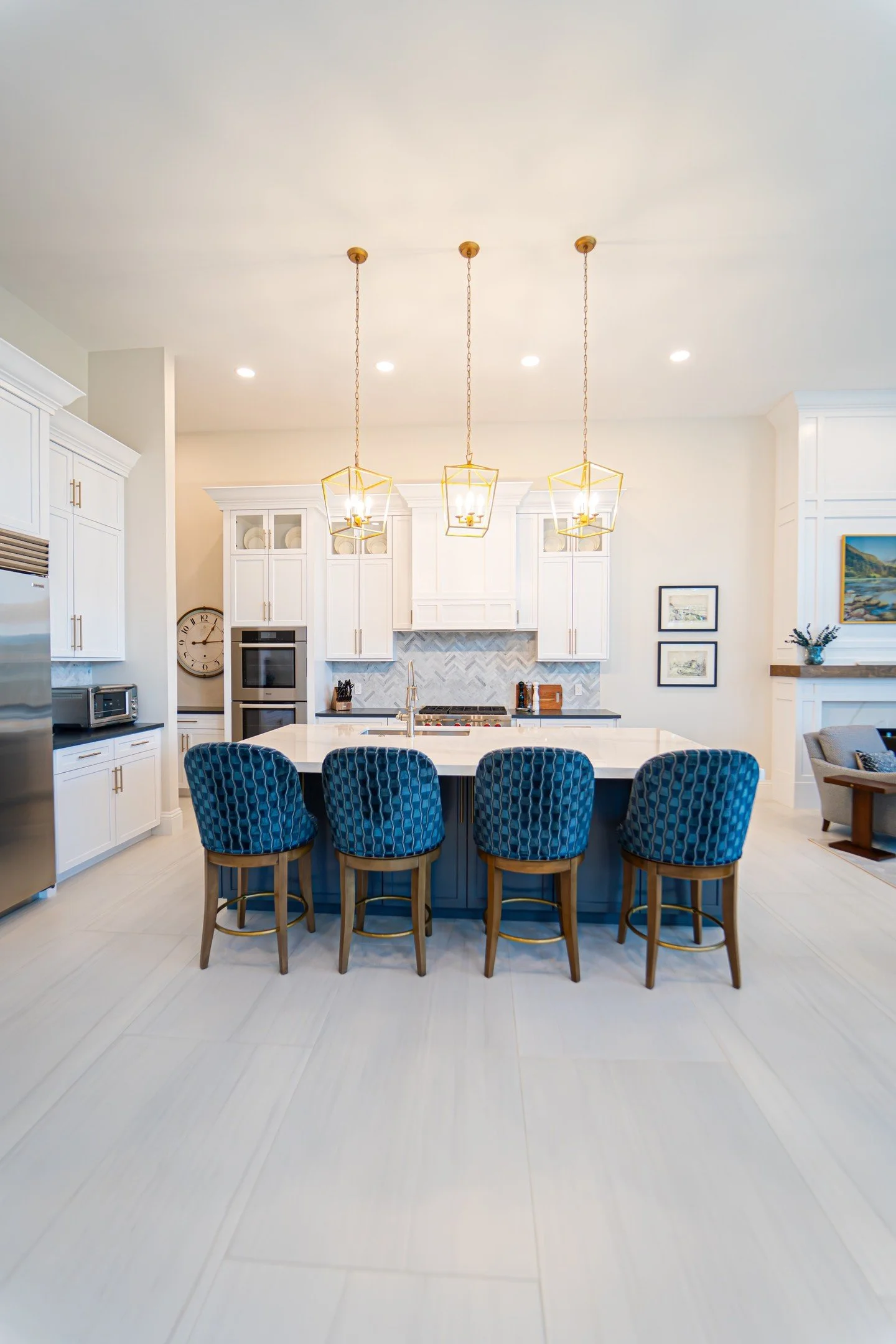 Could you see this in your home? This kitchen is a stunning blend of classic style and modern function. The oversized island offers plenty of space for cooking, gathering, and entertaining, while the bold blue bar stools bring a pop of personality to