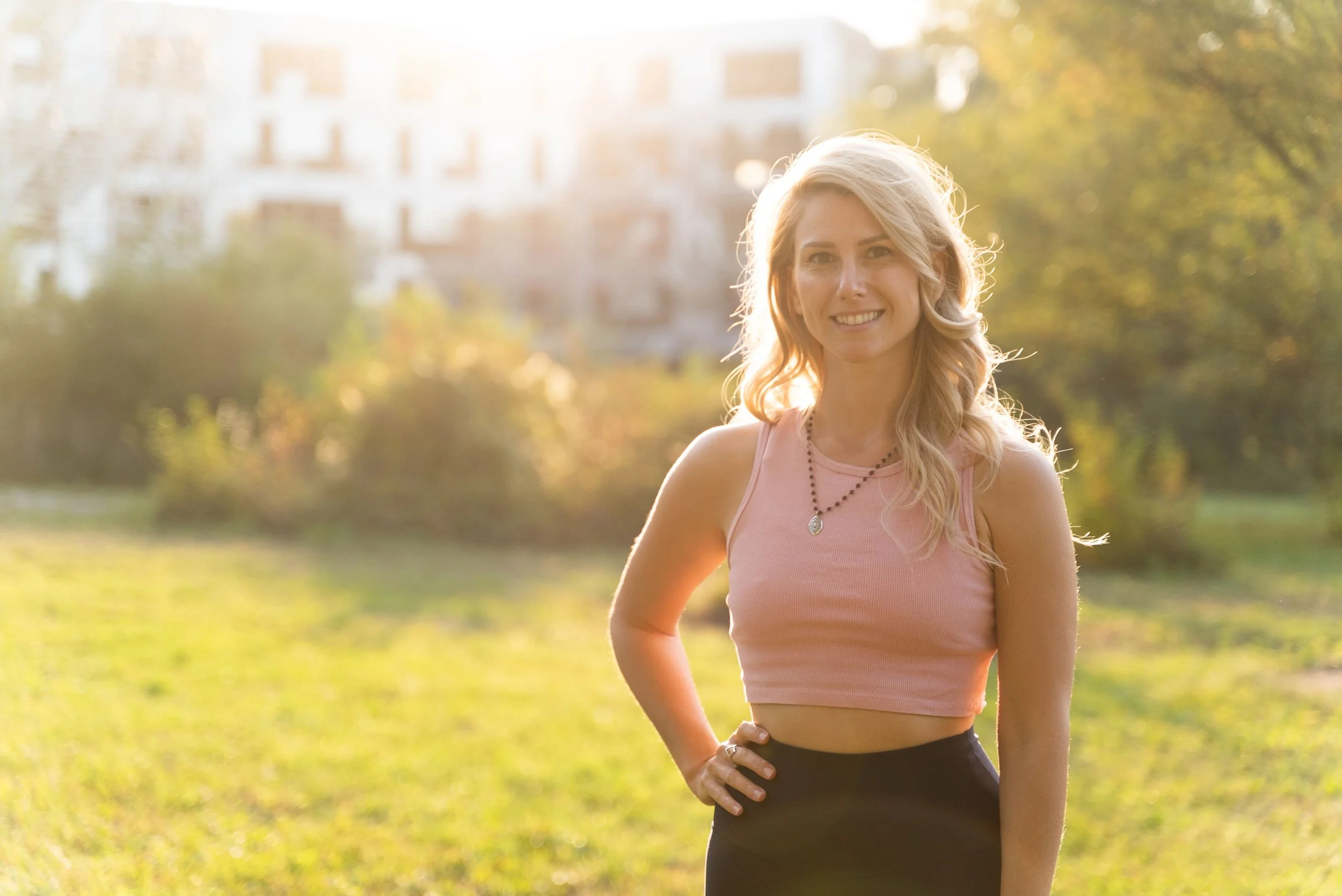 Photo of Rebecca Michelle, an online meditation coach, with a hat on smiling outside.