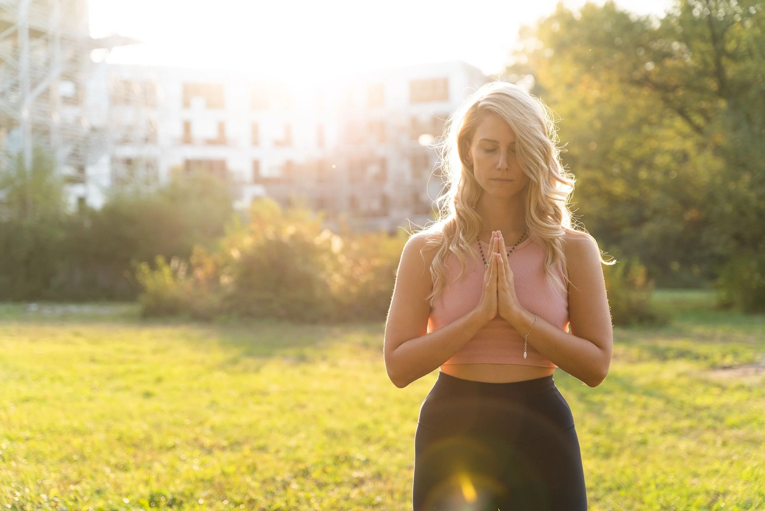 photo of Rebecca Michelle, a private meditation coach with her eyes closed meditating outside during the day