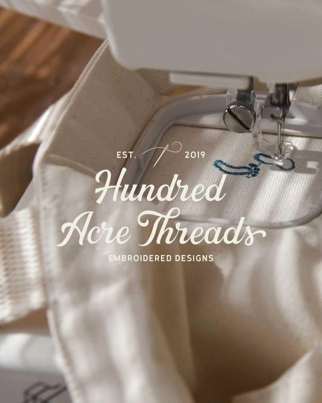 Hundred Acre Threads script logo over image of embroidery machine