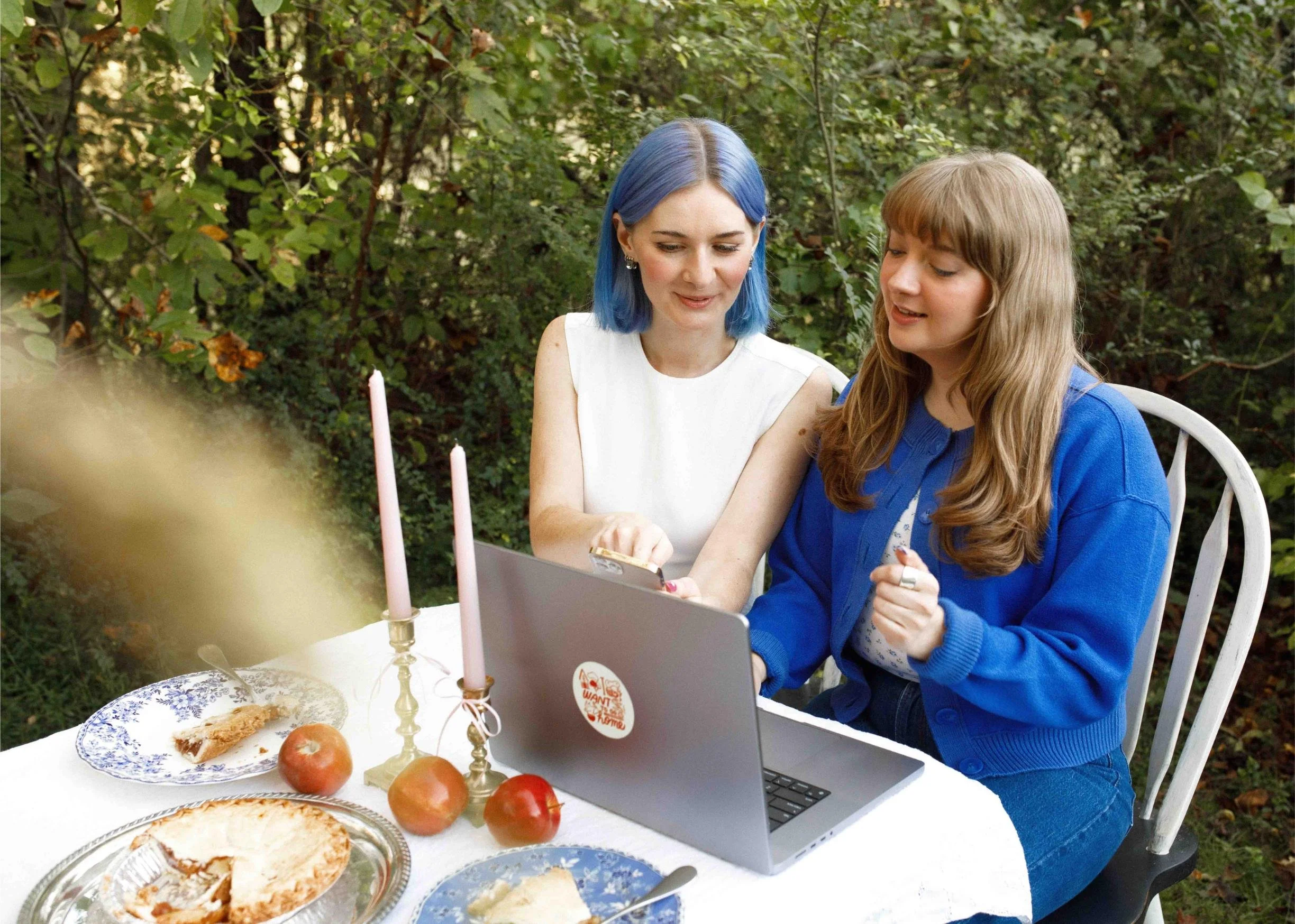 Foxtrot Cofounders Cass and Amanda working together outside at a table with a laptop, phone, and picnic items
