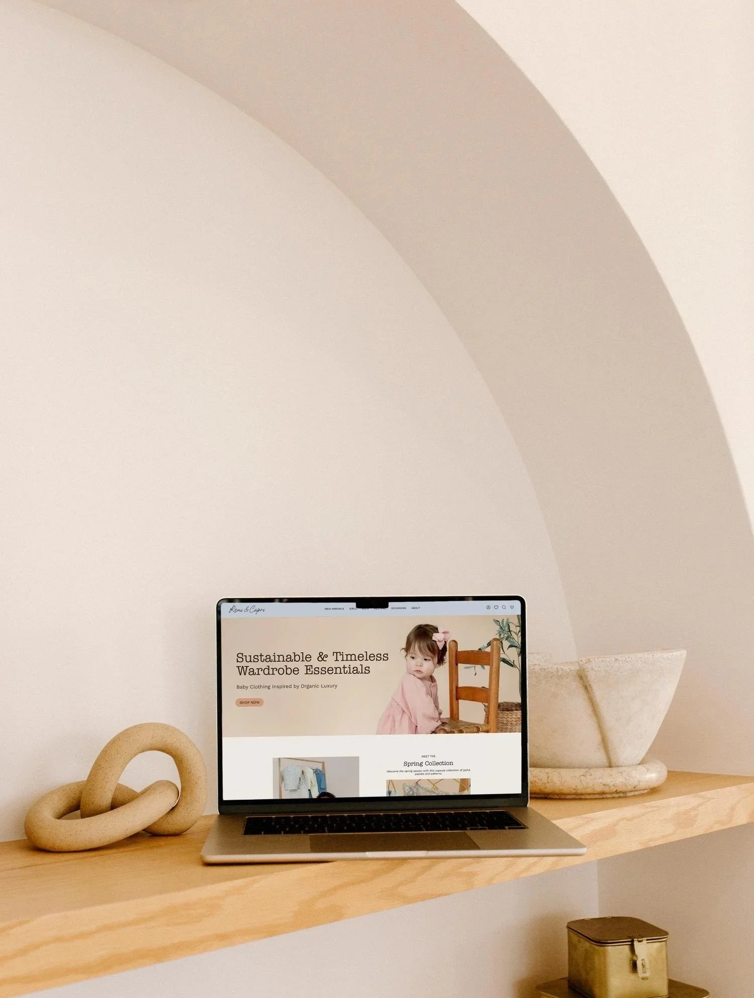 Wood shelf with a laptop on it with the Remi & Capri Shopify website showing