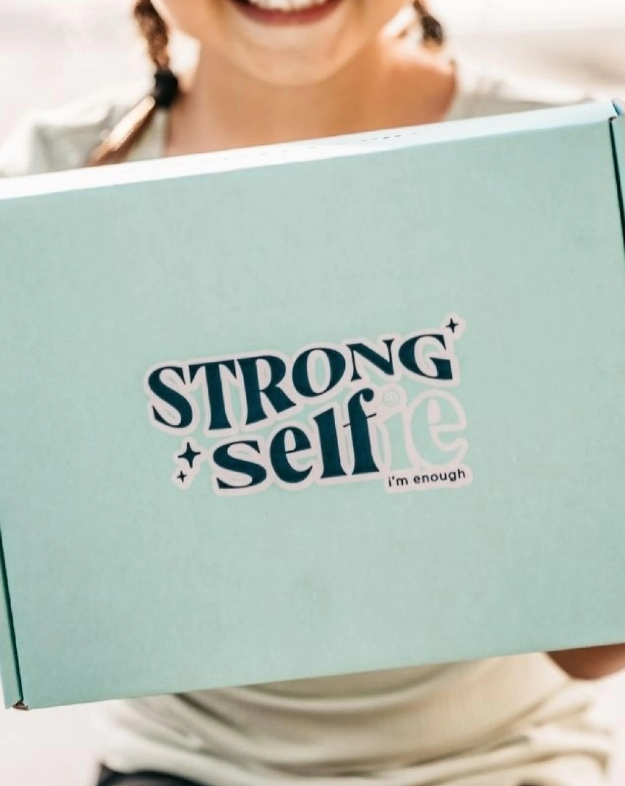 Girl holding blue mailer box with strong selfie logo on it