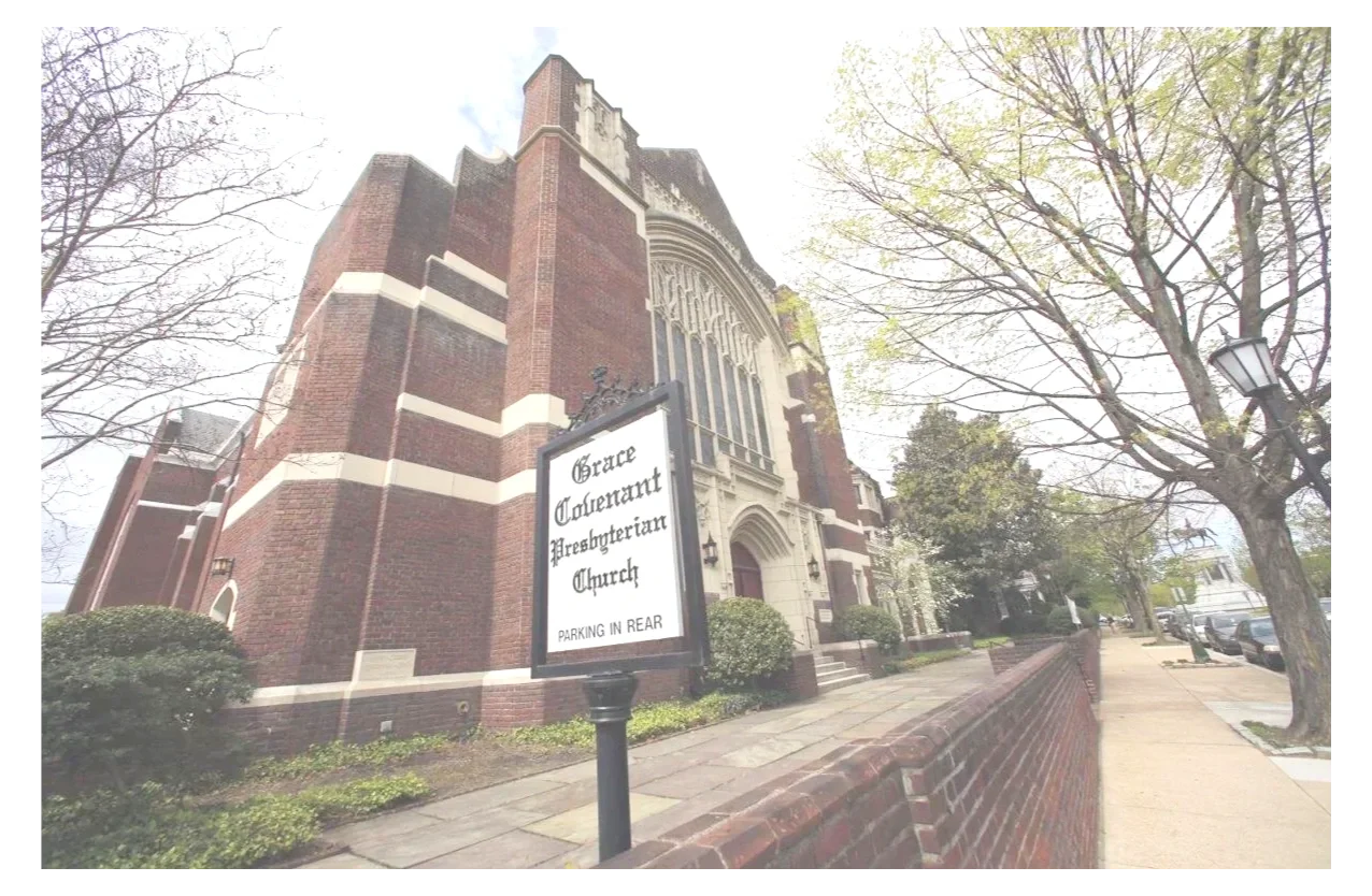 Exterior view of Grace Guarant Presbyterian Church on a cloudy day, with trees, a brick sidewalk, and parked cars along the street.