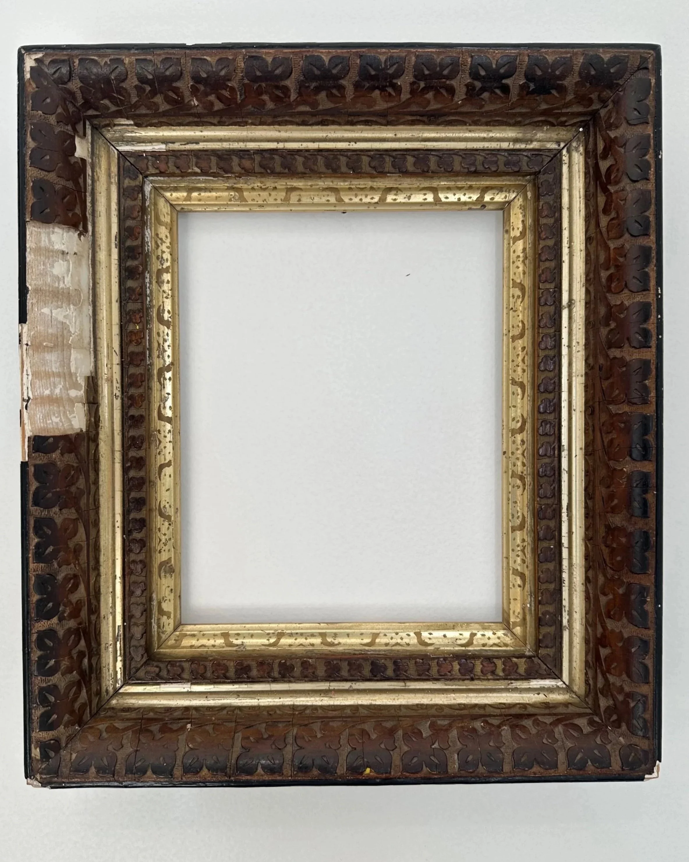 A decorative antique wooden picture frame with gold and dark brown detailing, featuring intricate carved patterns.